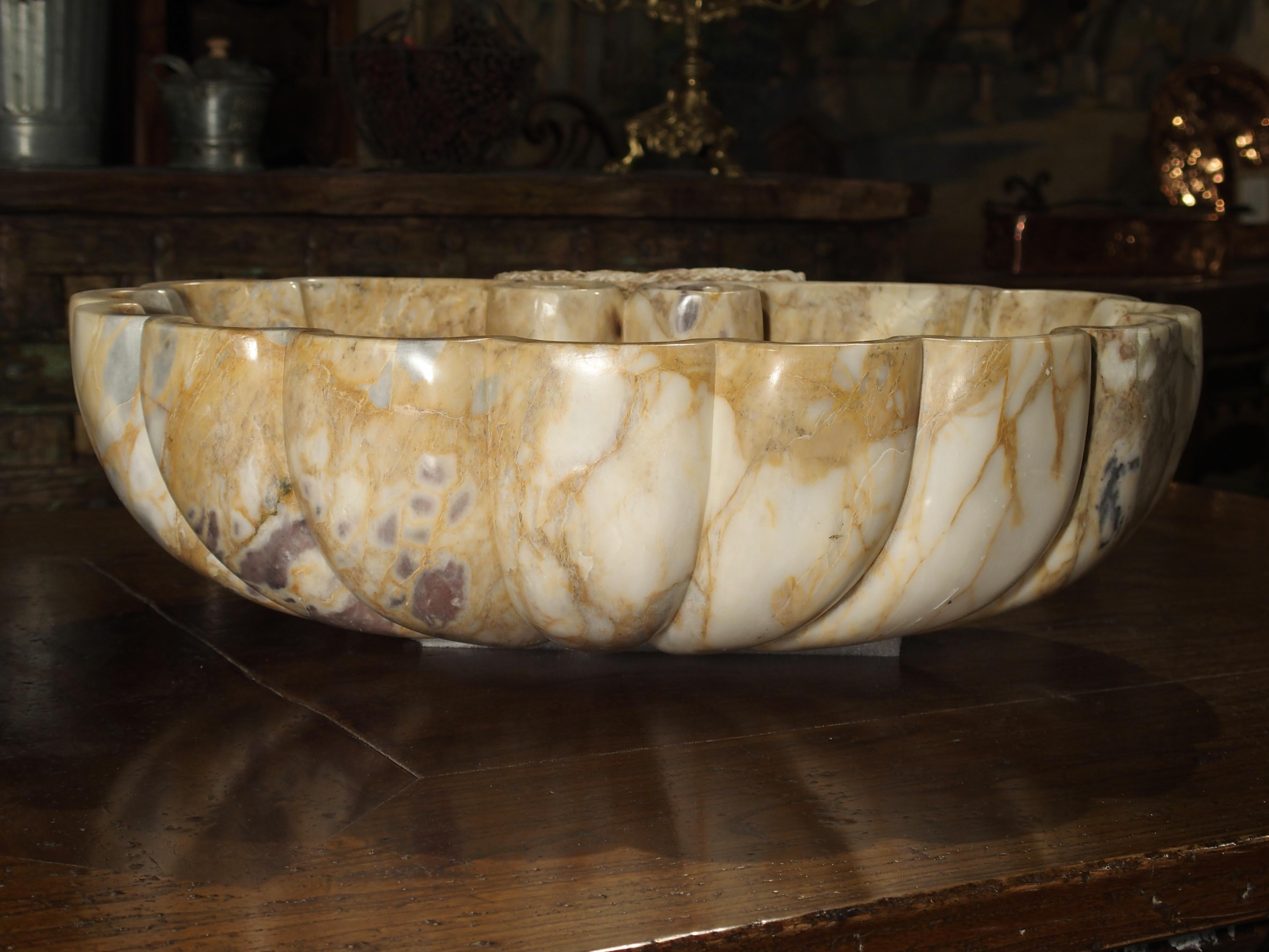 This elegant shell form Breccia marble sink will bring beauty to any surface it is placed upon. The colors of the marble are ochre, cream, and light grey with veins of chocolate brown and tan. This allows it to go with practically any color scheme.