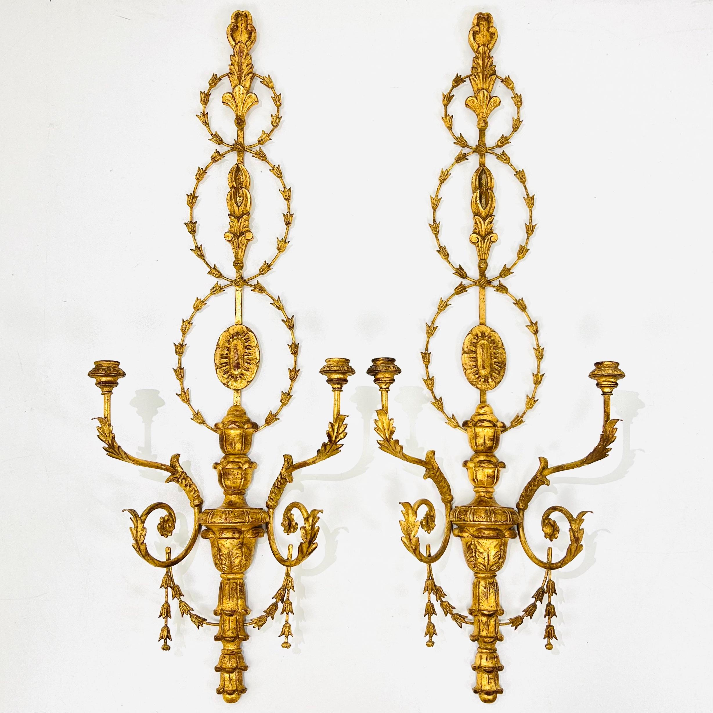 Pair of stunning, large scale carved wood and iron wall sconces finished in distressed gold leaf. Very good condition with minimal use. Not currently wired but drilled and ready for re-wiring. Made in Florence, Italy.