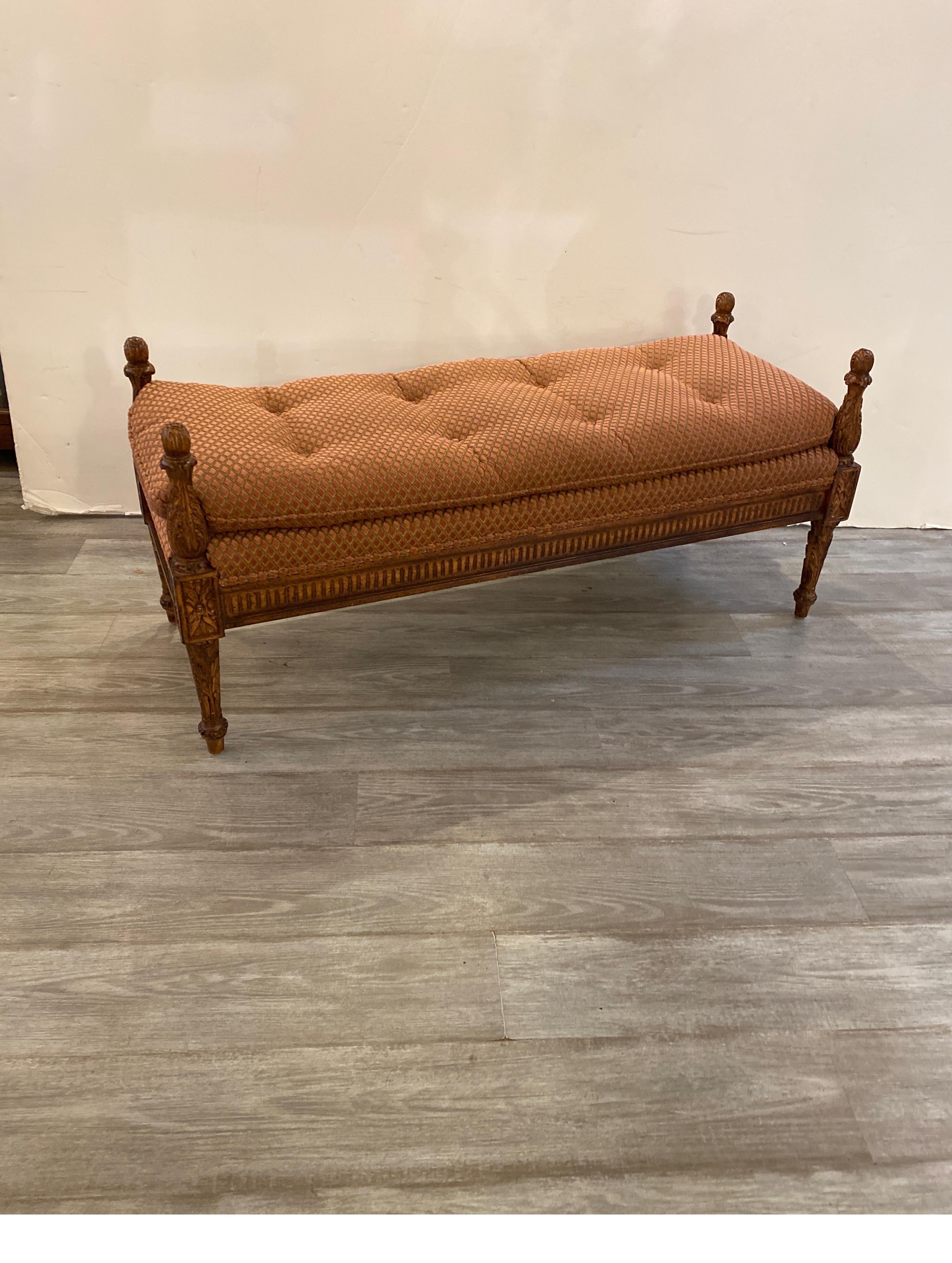 An Italian Provincial upholstered bench. The carved frame with a lighter wood color with diamond chenille fabric, with a down and feather pillow topped buttoned cushion.