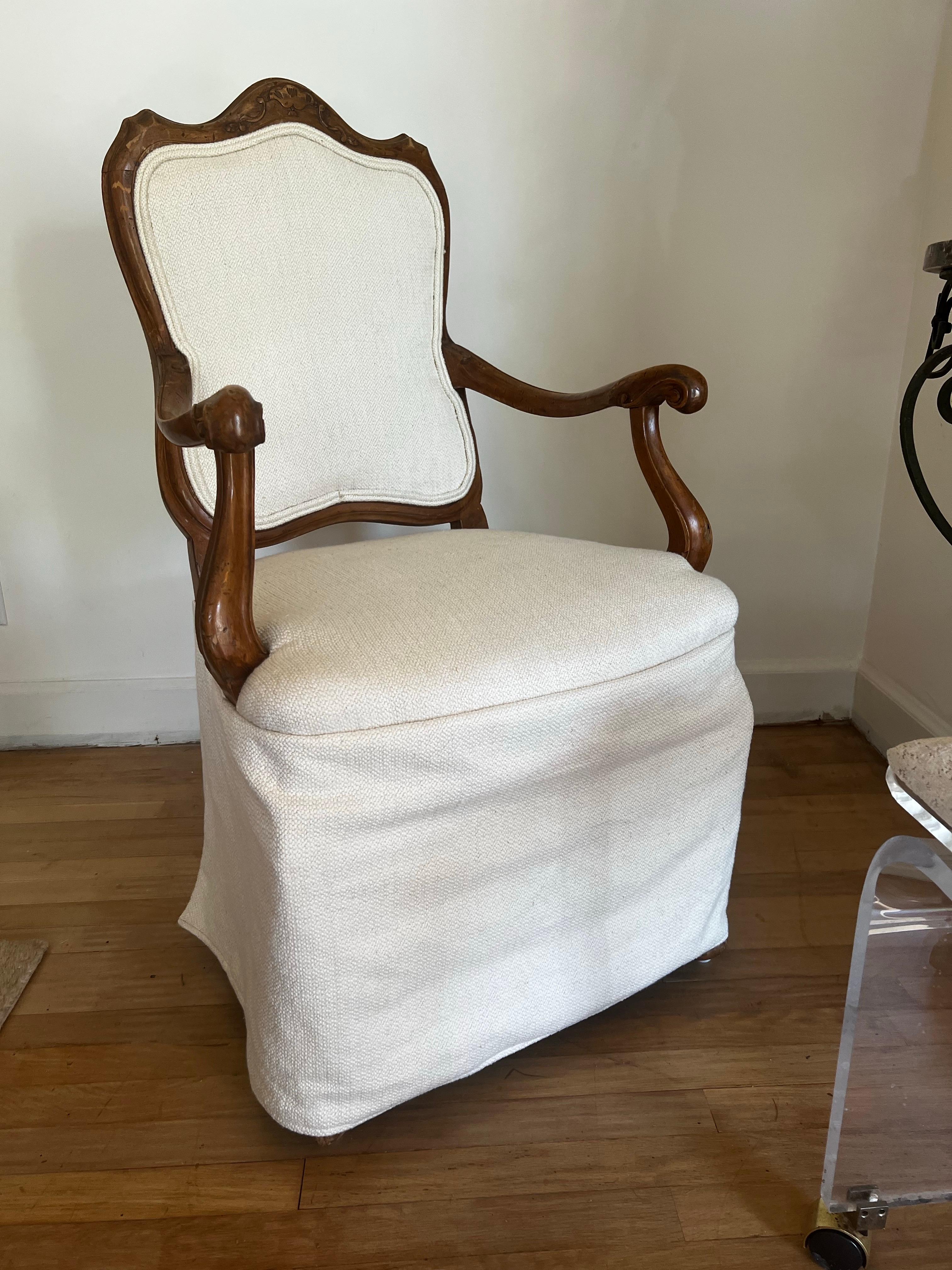 Stamped Made in Italy.

Antique Solid Walnut carved armchair with off white skirted upholstery. 
Unique and sophisticated carved detail on arms and legs.   

East coast delivery from NC available.