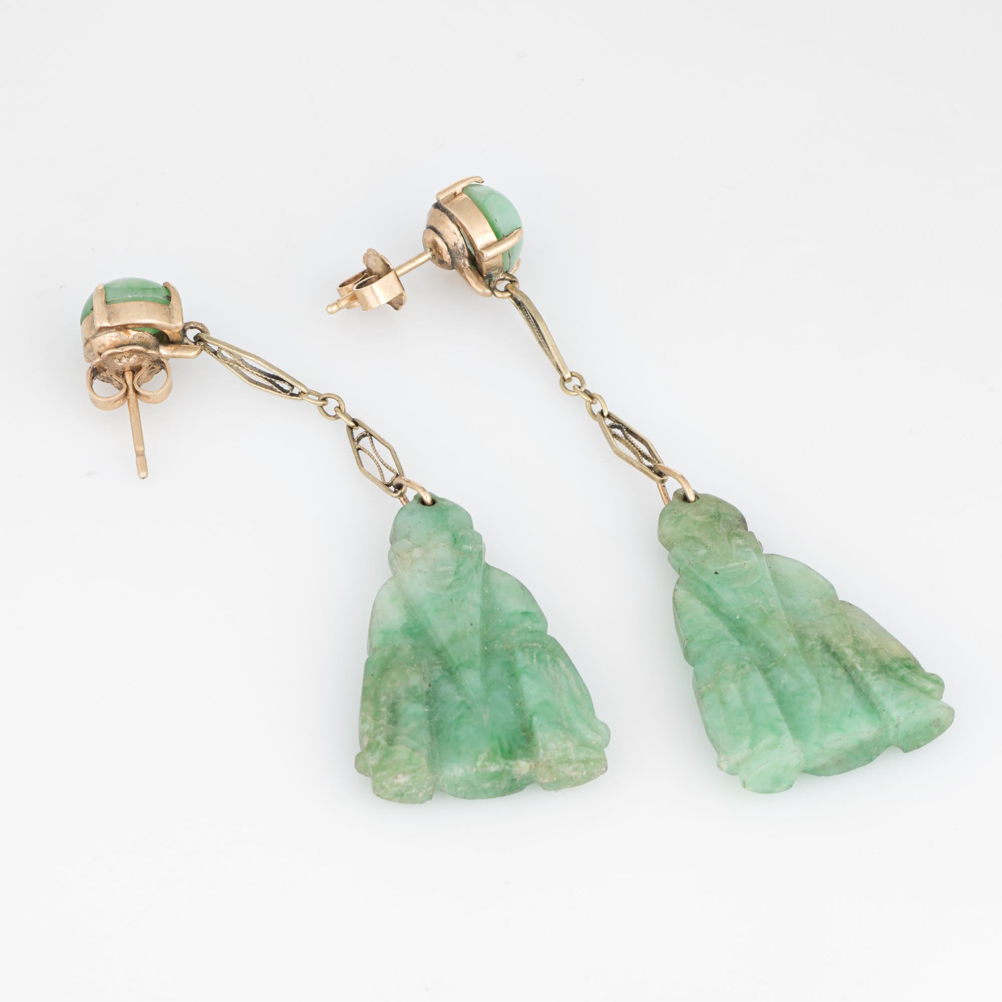 Elegant pair of vintage carved jade buddha earrings (circa 1950s to 1960s) crafted in 14k yellow gold. 

Jade measures 28mm x 18mm (lower) and 8mm (upper). The jade is in excellent condition and free of cracks or chips. 

Jade is carved in the form
