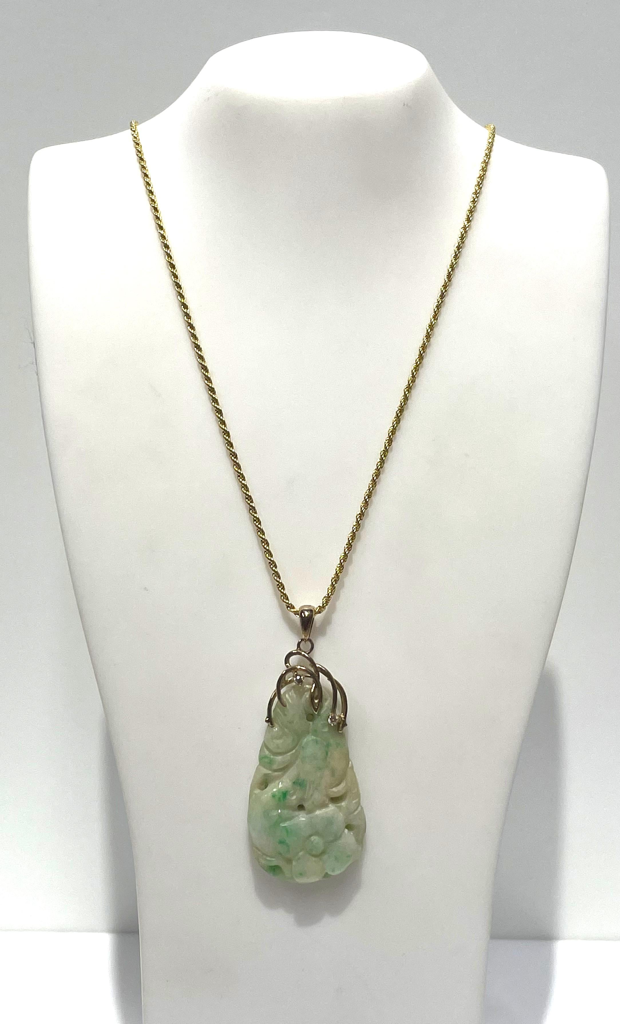 This beautiful jade piece will be a favorite! 
Pear shape carved jade pendant with decorative 14 karat yellow gold top.  
Overall pendant is approximately 44mm long x 21mm wide.
Decorative top has two round prong set diamonds approximately .03ct
