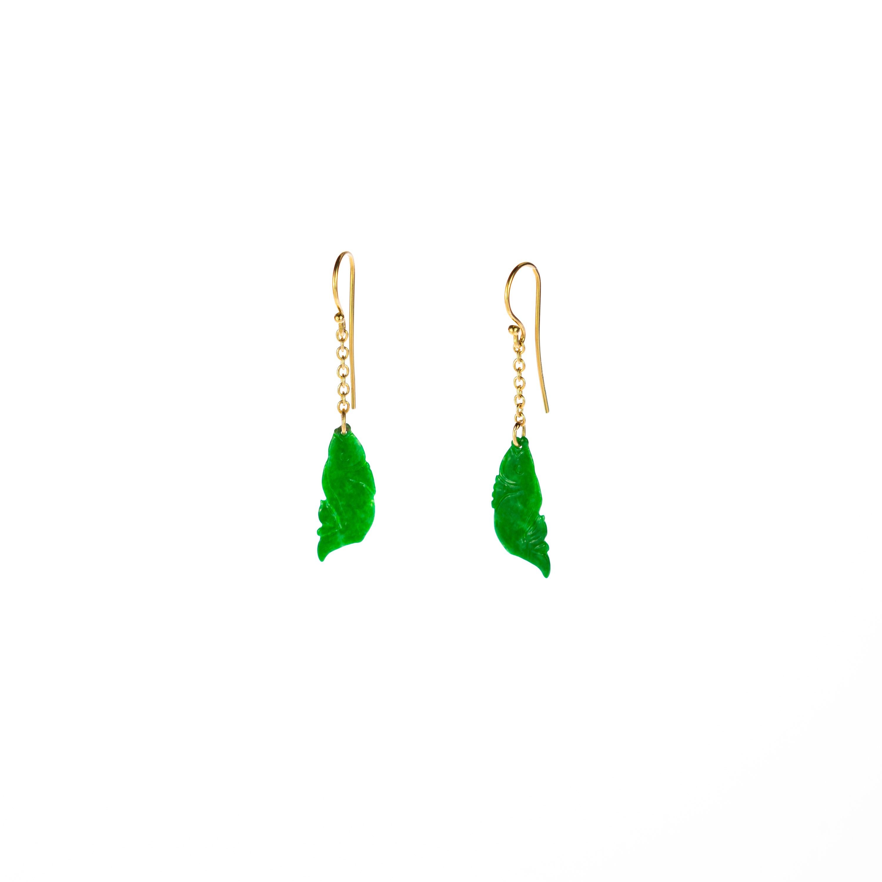 A stunning 18 karat yellow gold earrings chain that ends in a traditional and unique natural jade stone. The green precious stone is carved in a fish shape with a flower tale. Long, dangle drop earrings created for a bold and delicate look. 
 
These