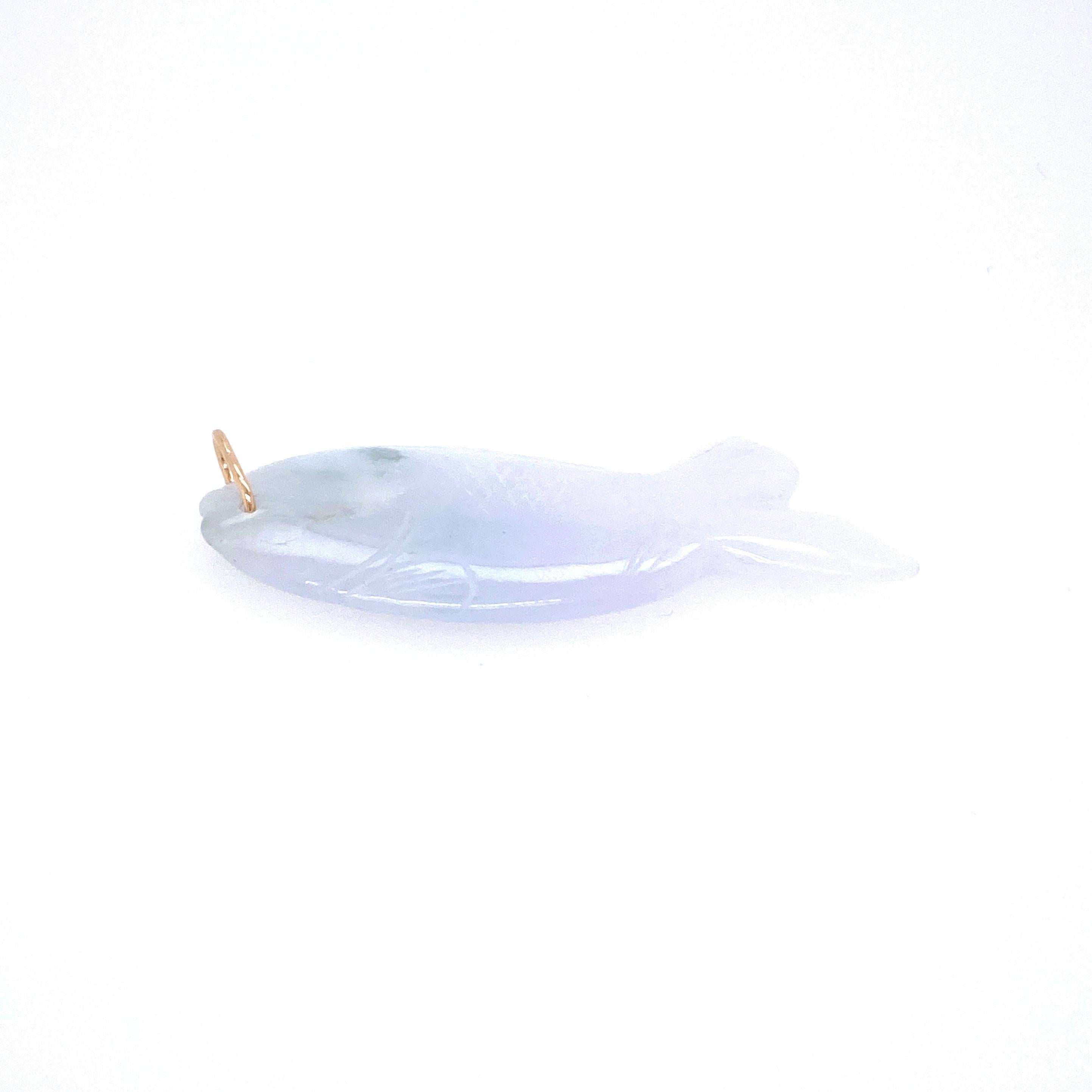 One 14 karat yellow gold (acid tested) carved jade fish pendant, measuring 2 inches x 0.75 inch.  