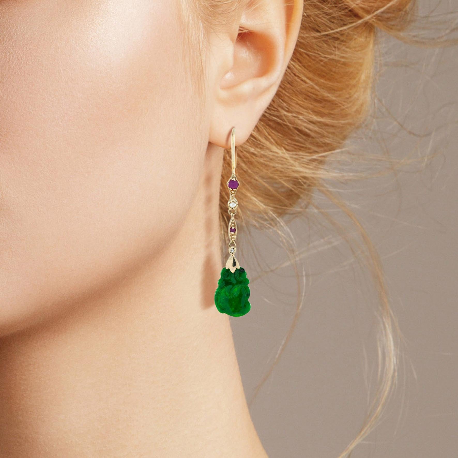 The natural jade in these lovely earrings has some very special shape. Both pieces have a strong green color and well carvings. The jade is suspended in a 9k yellow gold setting with ruby, pearl and diamond link on the top. The earrings transfer