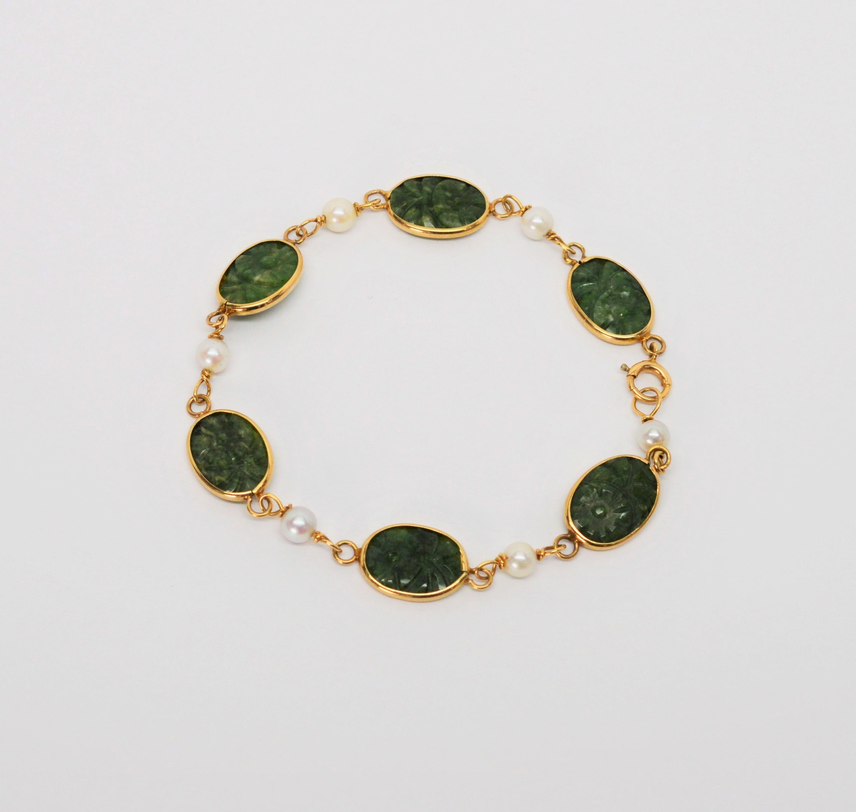 Beautifully hand carved jade plackets bezel set in ten karat (10K) yellow gold create unique links on this attractive bracelet. Lustrous white peals are placed between the oval shaped jade links accenting the natural beauty of both materials. Eight