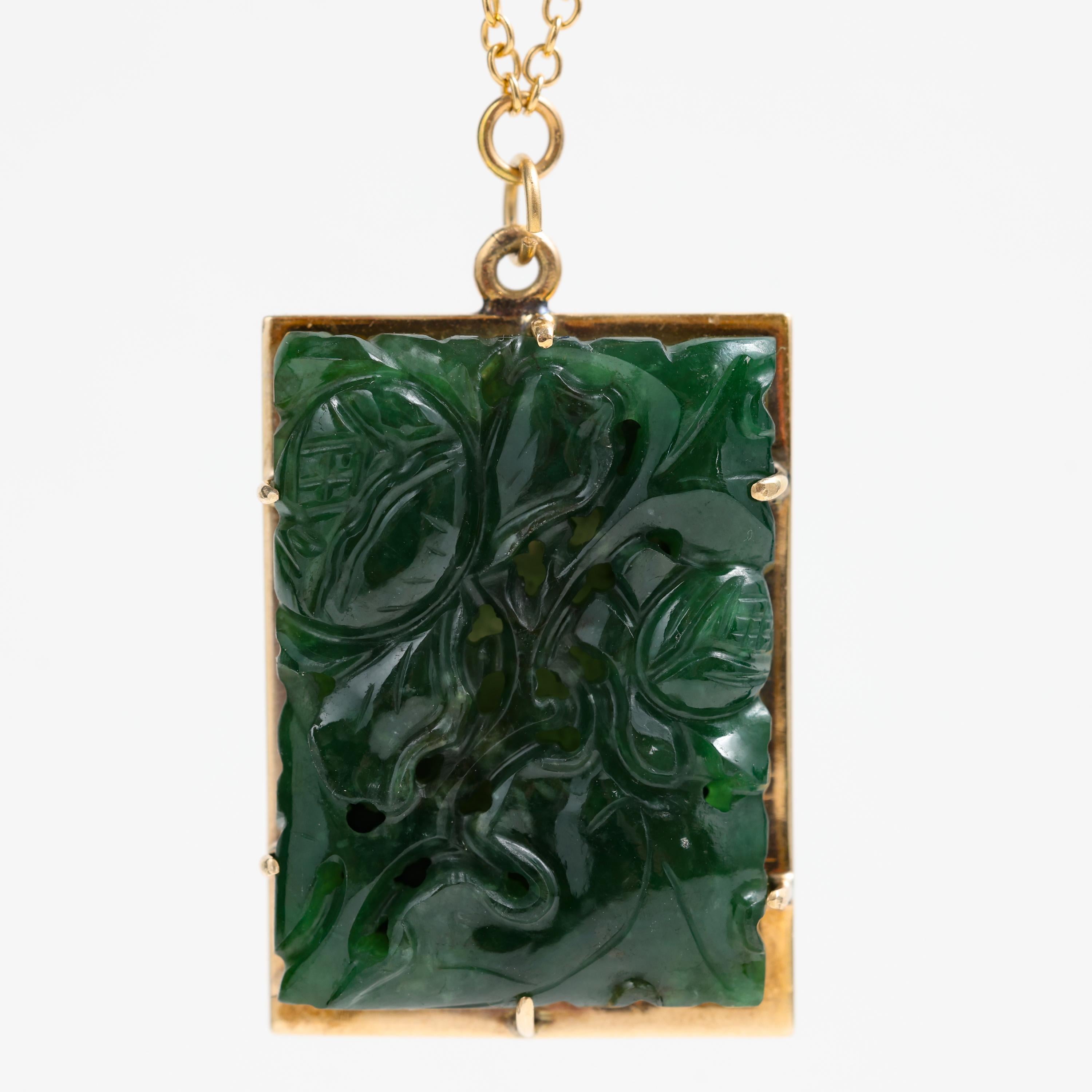 A gorgeous natural and untreated omphacite jade pendant from the midcentury -circa 1950. Created in Hong Kong, the jade has been carved and pierced into a floral motif. The tone of the green is a deep, rich forest green. 

The jade carving itself