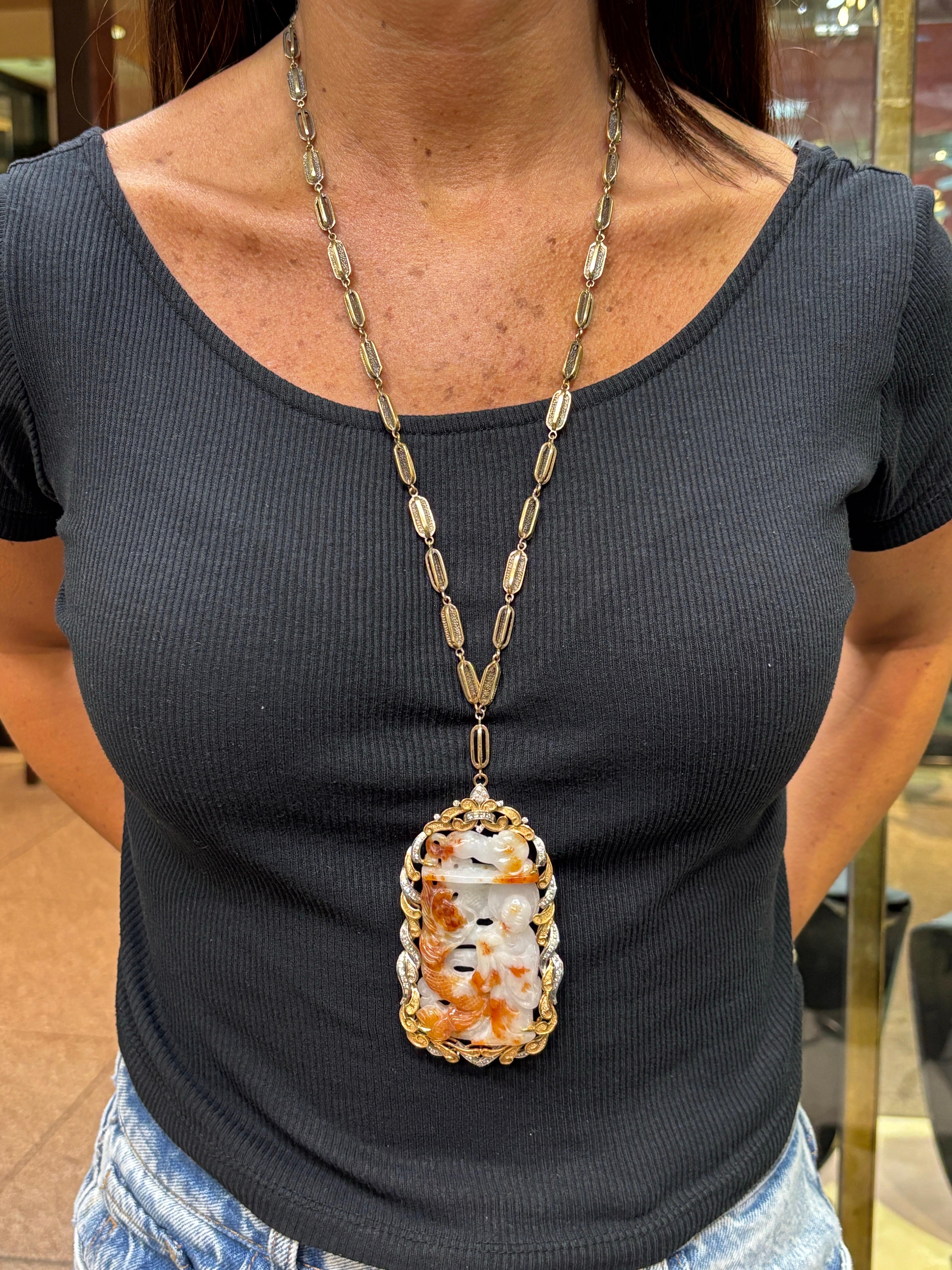 Collana con ciondolo di giada intagliata 

Una grande collana con ciondolo in giada intagliata che raffigura una donna e un drago incastonati in oro bianco e giallo, con diamanti a taglio rotondo. 

Peso approssimativo dei diamanti: 
Misure