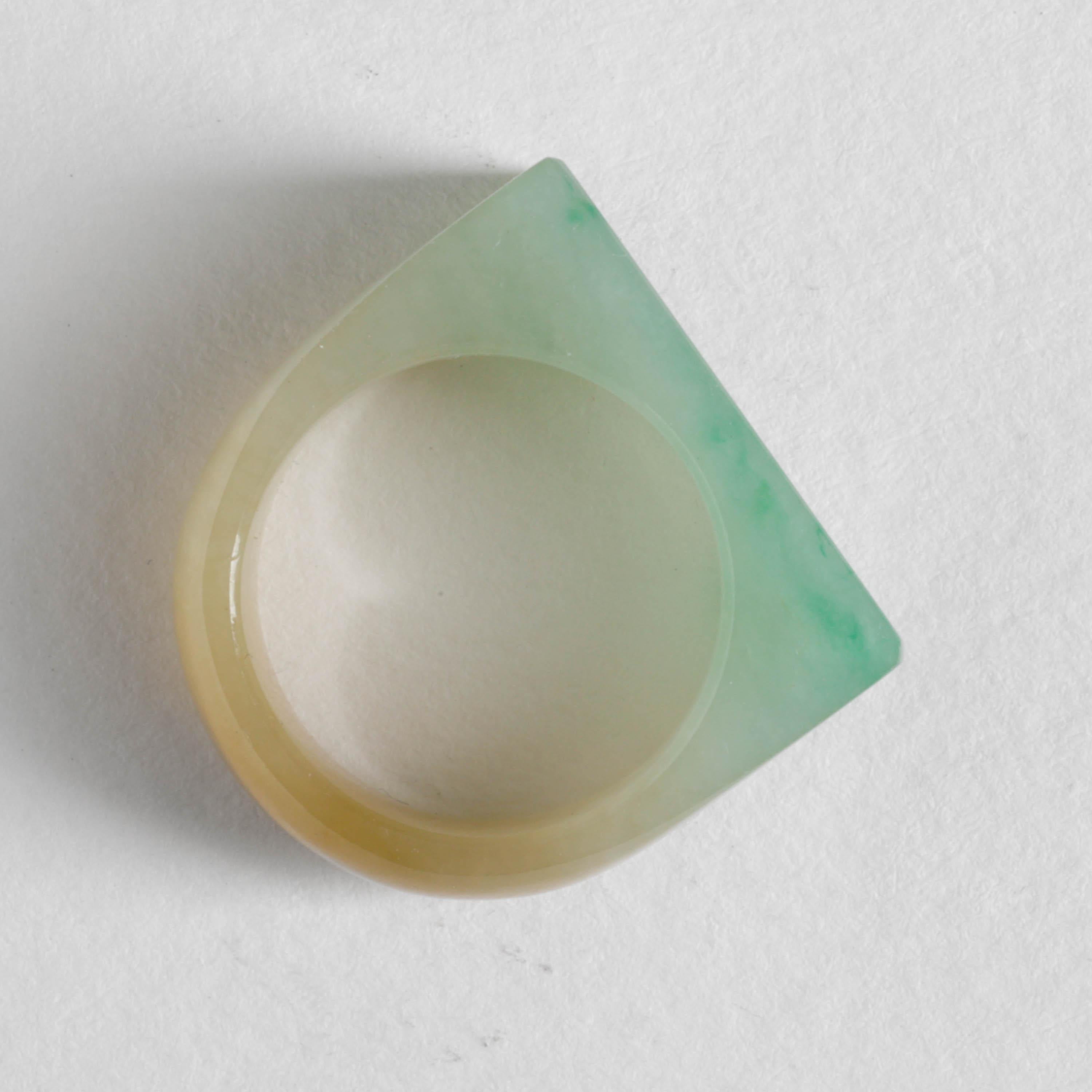 This is a highly translucent hand-carved new jadeite jade ring. It's a masterpiece of subtle and lapidary skill. The green face has been carved with a chamfered edge that gives this centuries-old style of ring a decidedly modern aesthetic. 

The