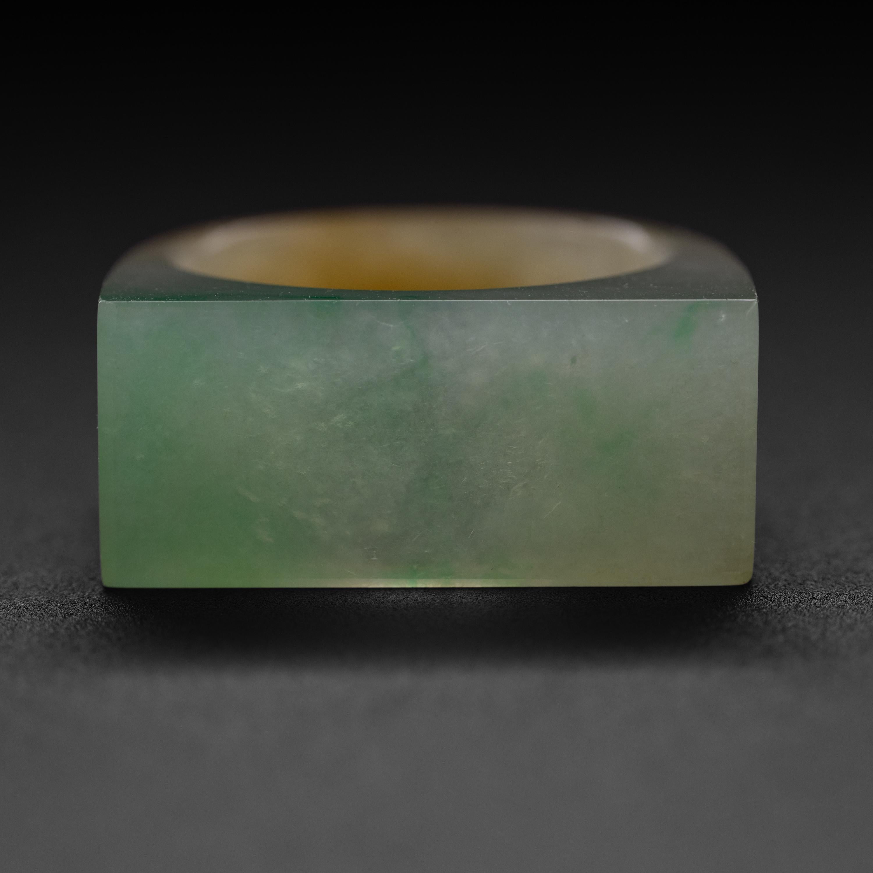 This is a highly translucent hand-carved contemporary jadeite jade ring. The green face has been carved with a fine and subtle beveled edge that gives this centuries-old style of ring a decidedly modern aesthetic. 

The ring displays extraordinary
