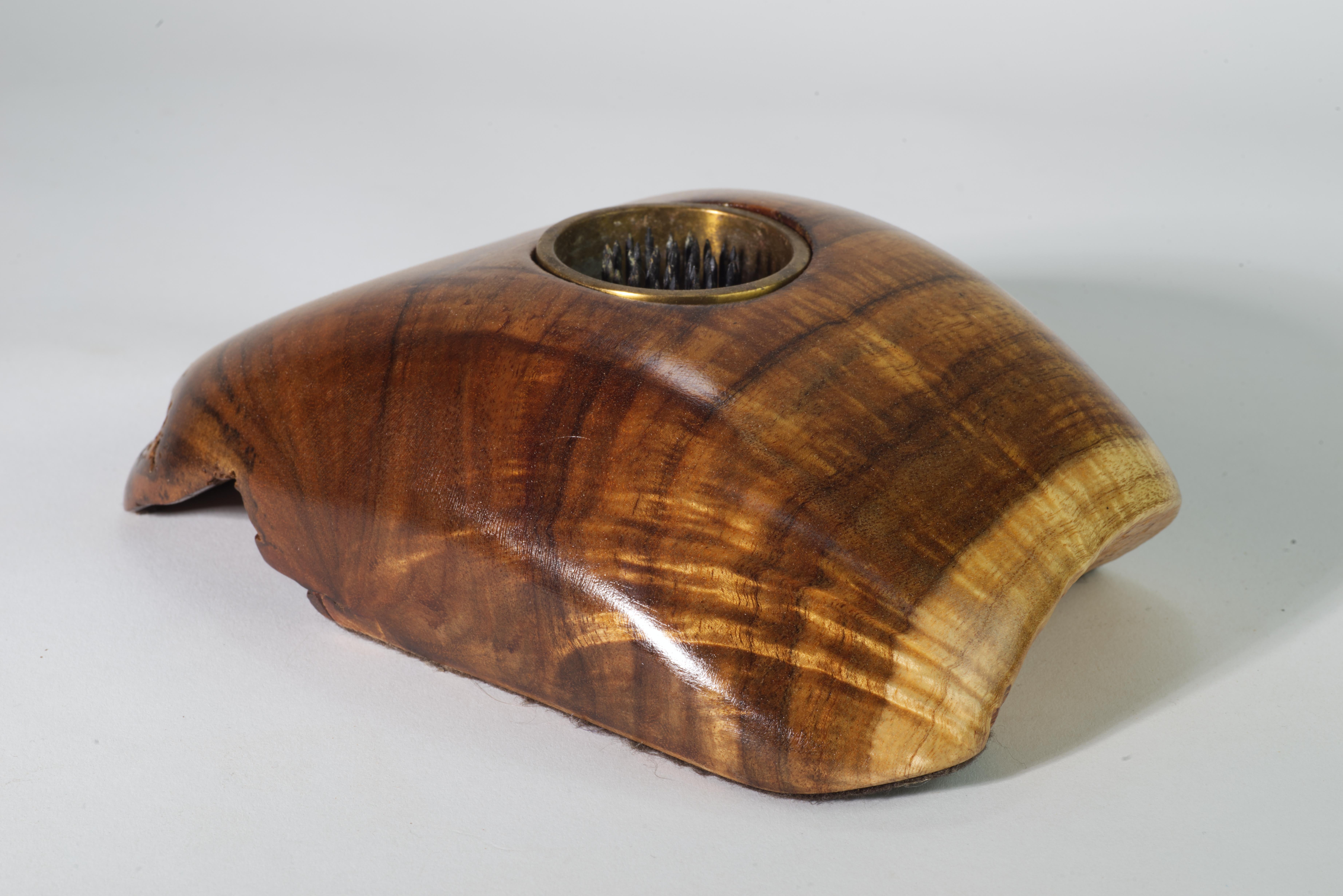  La vasija de madera de Koa tallada a mano, de forma asimétrica y orgánica con borde vivo, está equipada con un jarrón de latón con una rana para acomodar arreglos ikebana. Está firmada y fechada en la parte inferior por el artista.

La Koa