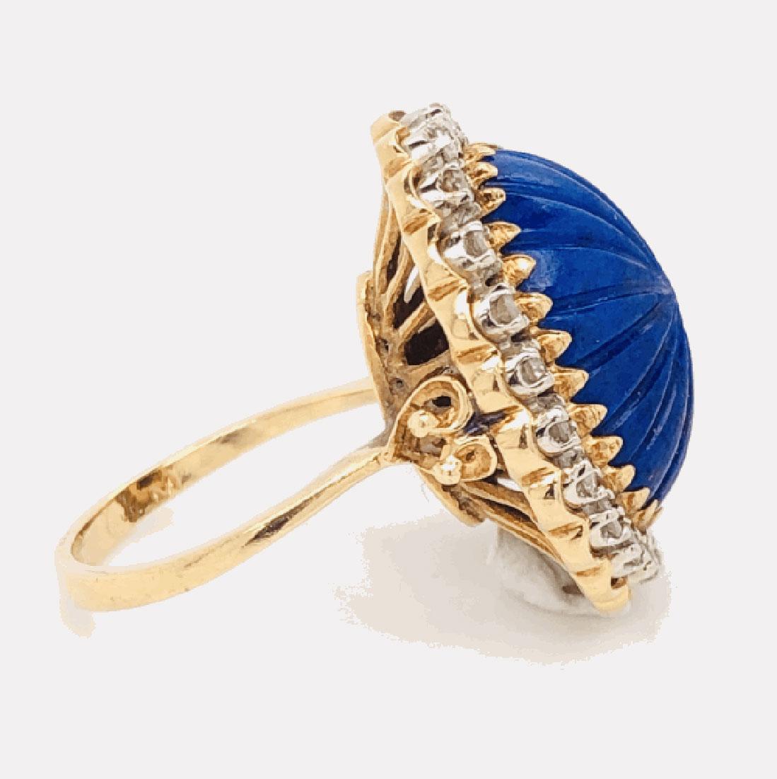 Elegant and finely detailed Lapis Lazuli Cocktail Ring, center set with a Carved Cabochon Lapis Lazuli, bright blue with fabulous tones and small gold flecks, surrounded  with Diamonds weighing  approx. of 0.45 total Carat weight. This beautiful