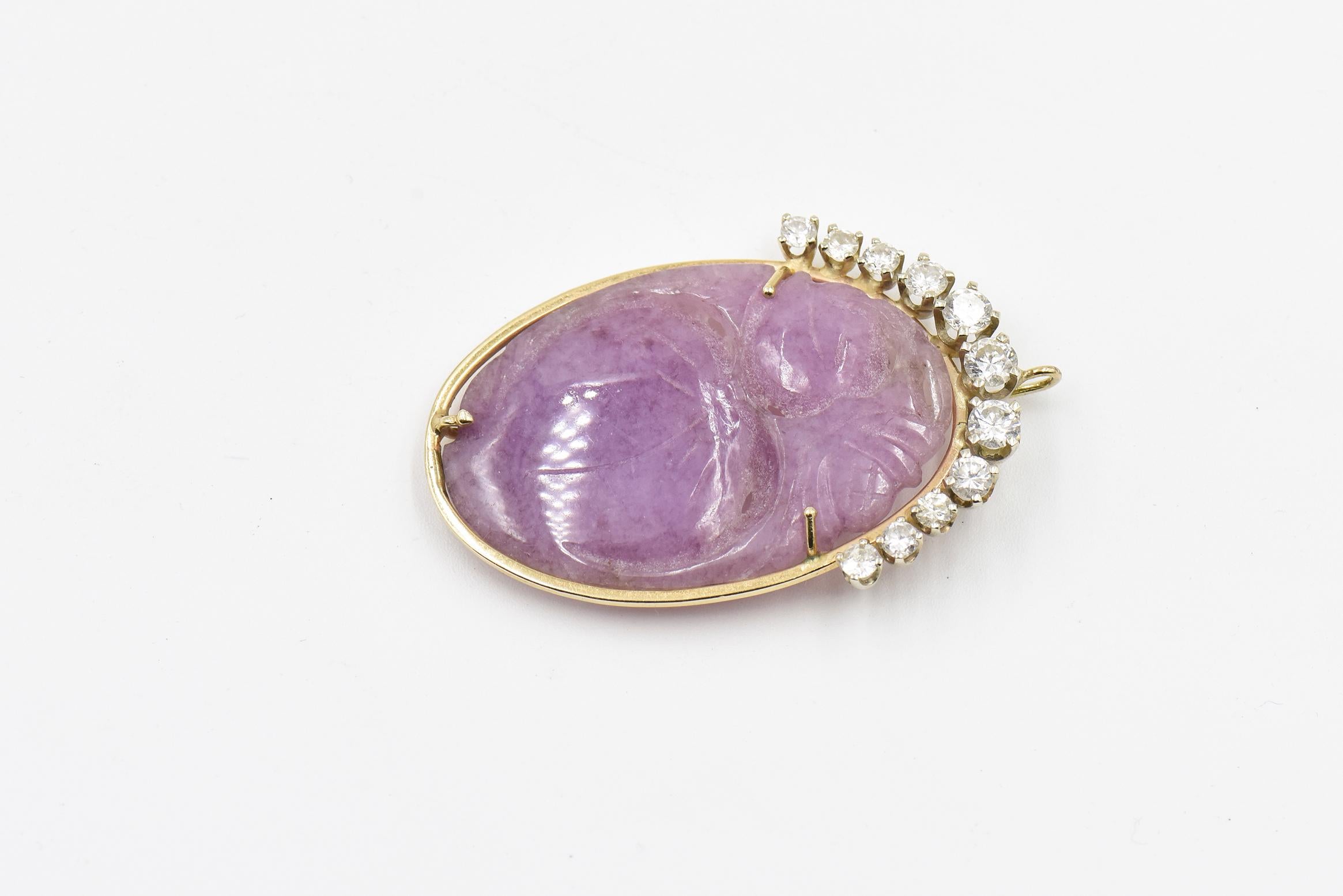 Pendant centrally set with a hand carved lavender jade featuring a plum design exhibiting a nice transparency and good sheen set in a 14k gold frame topped with 11 graduating round brilliant cut diamonds with an approximate total weight of 1.50