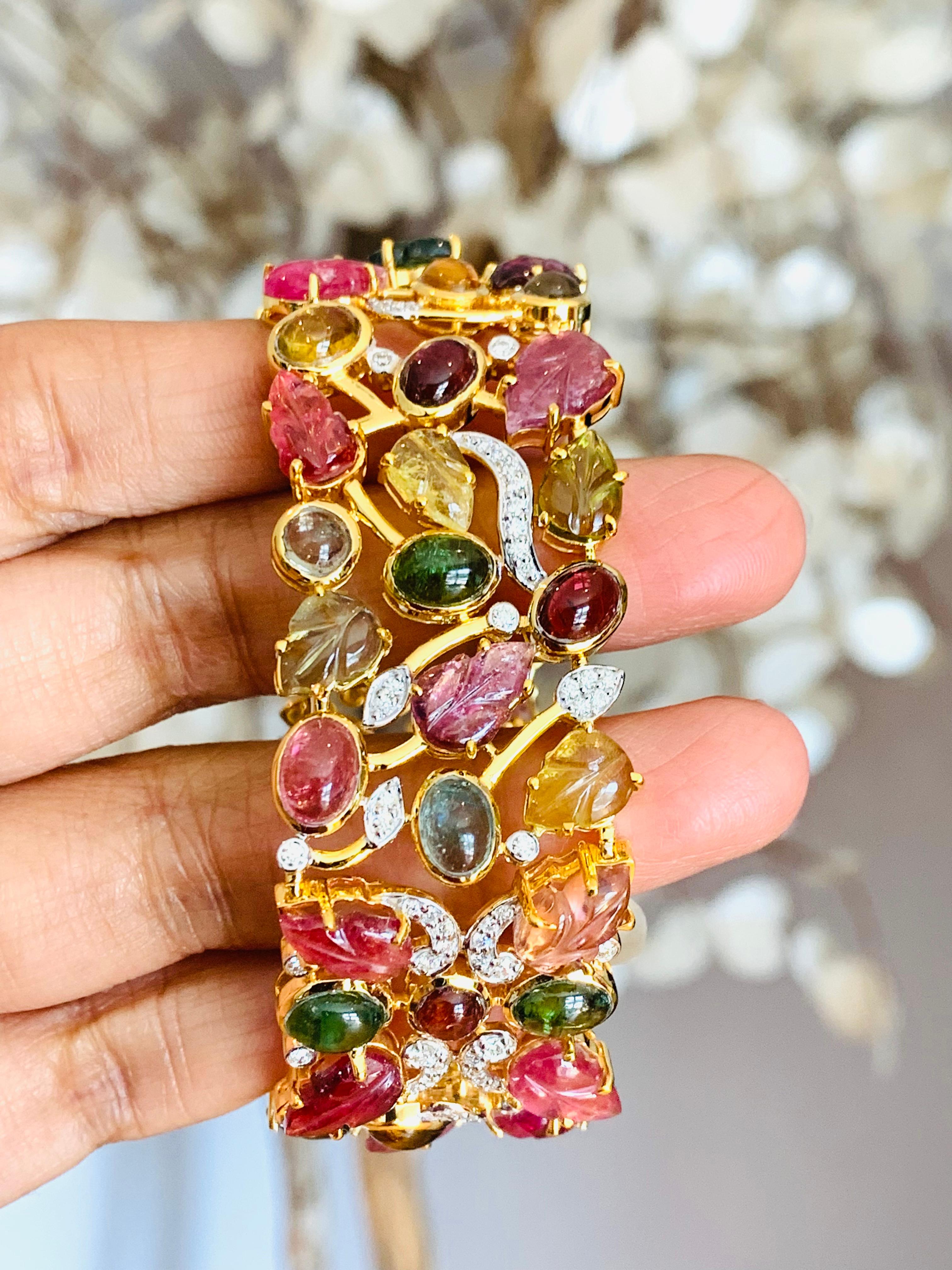 A stunning statement cuff handmade in 14K gold and hand carved leaf motifs set throughout. It is set in 55.74 carats tourmaline, ruby, sapphire & 1.74 carats of sparkling diamonds. Clasp Closure

FOLLOW  MEGHNA JEWELS storefront to view the latest