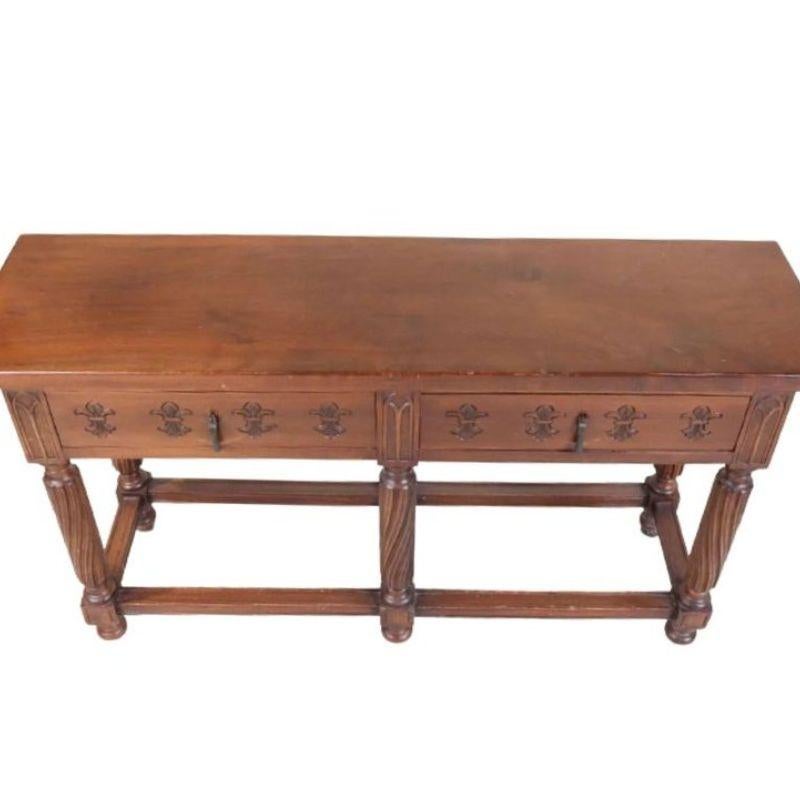 A vintage Jacobean style mahogany table with six carved legs ending on bun feet with straight stretchers, and two drawers with carved detail.