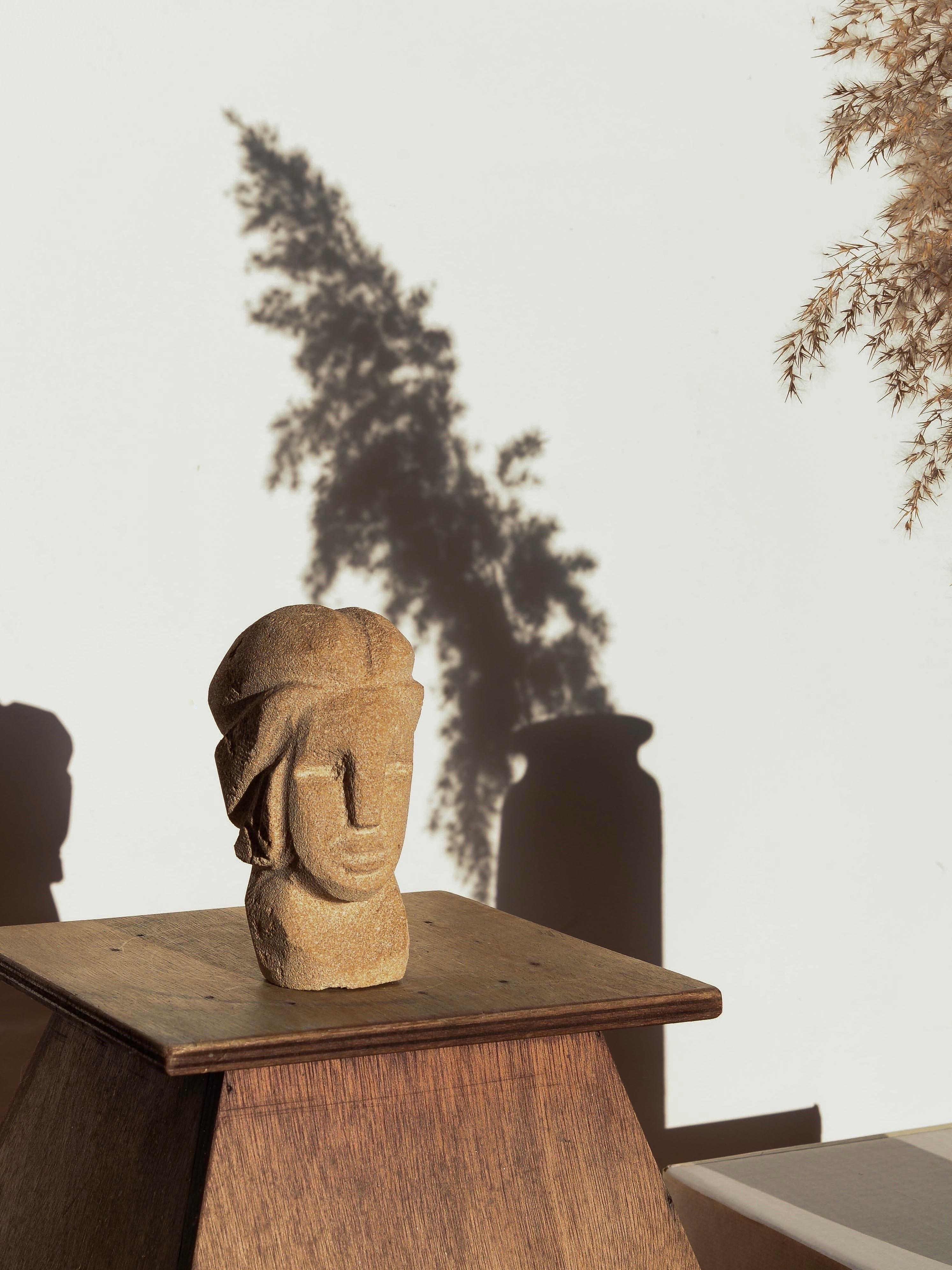 Sculpture en pierre calcaire d'un visage énigmatique et très élégant, sculptée de manière complexe, France, Circa 1970. Les traits du visage, d'apparence masculine, émergent de la pierre par des lignes taillées de manière plutôt graphique et
