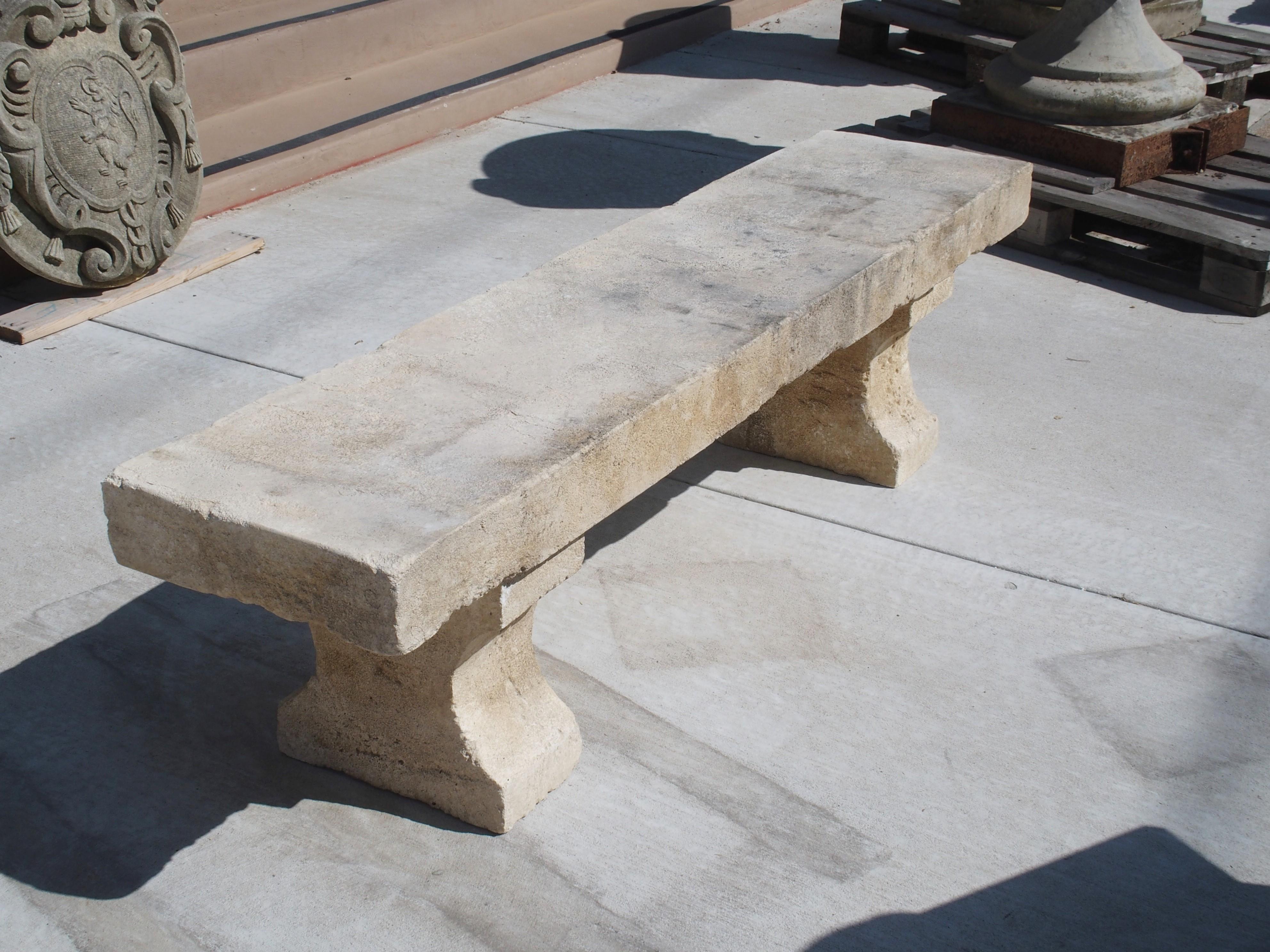 This classic hand carved limestone park bench is from Provence, France. The seat is one thick, solid piece of stone that rests upon two shaped block feet. Perfect for placing with a table or left on its own in a garden, this French stone bench will