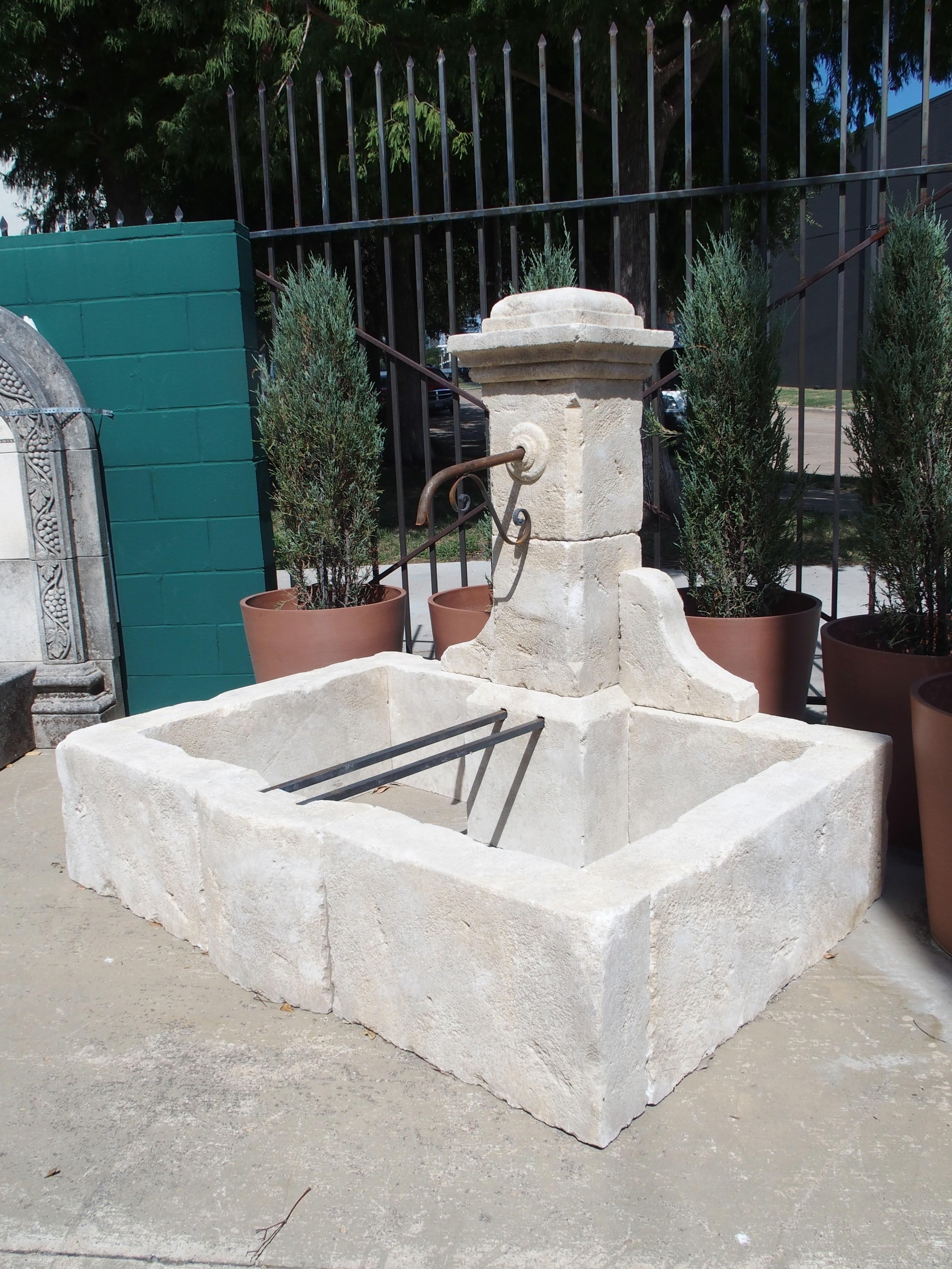 Consisting of 14 pieces of Estaillade limestone, this single-pillar fountain was hand-carved in the South of France. A subtle bombe curve embellishes the front of the basin, just in front of a pair of iron bars that extend from the basin wall to the