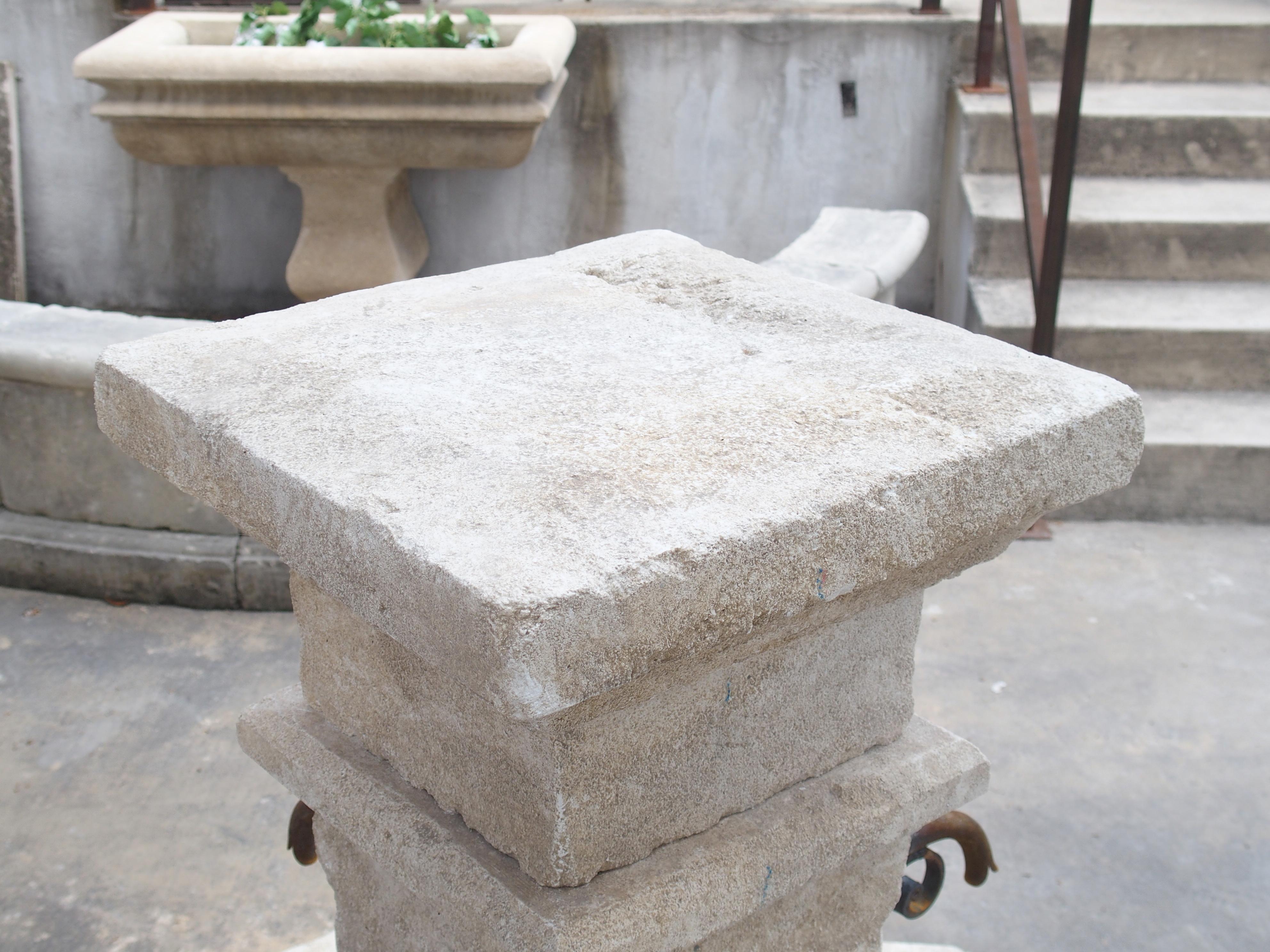 This hand-carved limestone village fountain from Provence, France features an octagonal basin with canted top edges. The pillar is comprised of six stones of various sizes, but all are square or rectangular in shape.

A flat square finial with