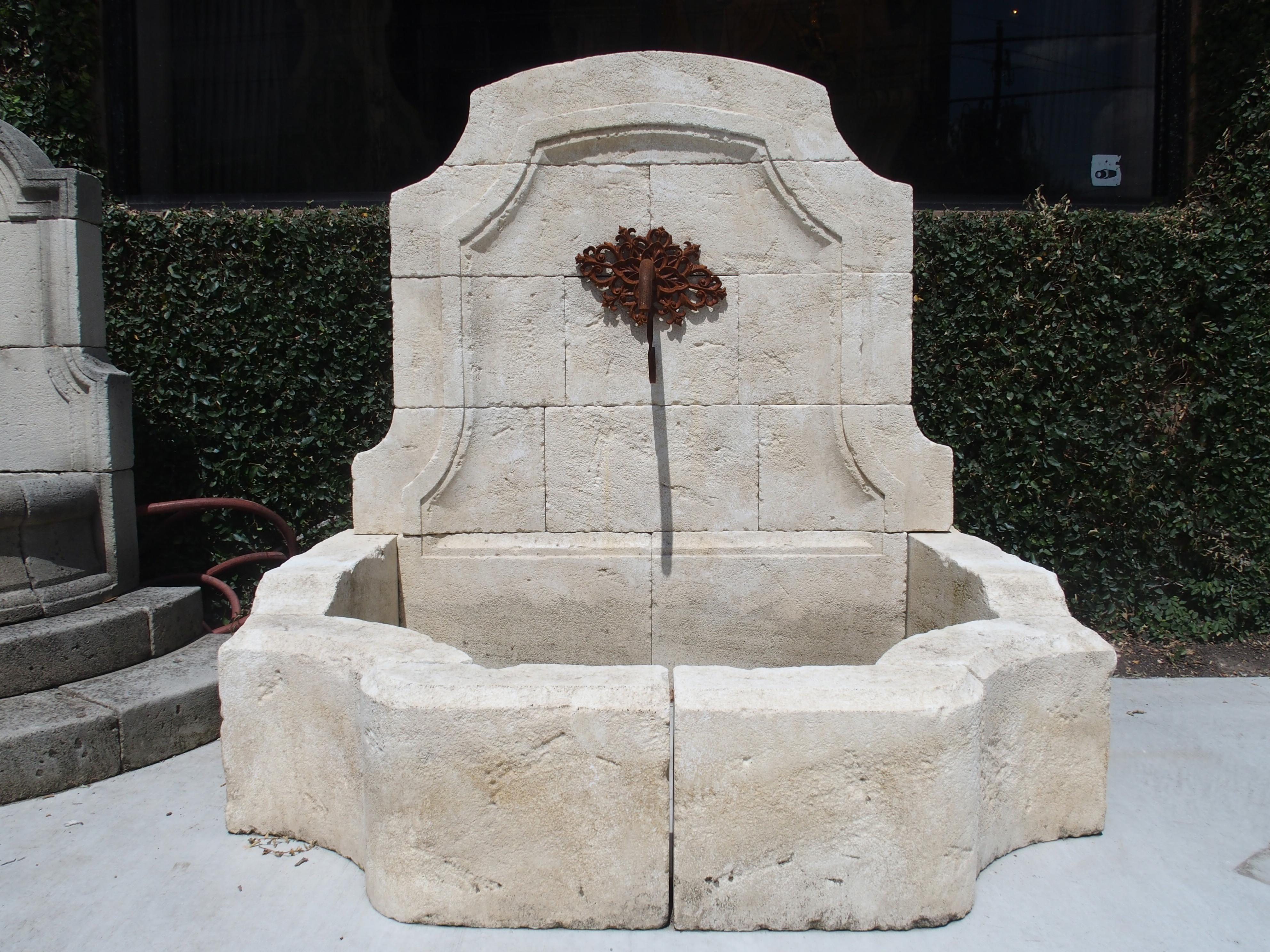 This elegant wall fountain from Provence has been hand carved in Estaillade limestone. The back has a domed top with canted corners and stepped out bases atop the basin. On the inside back, there are raised double moldings mirroring the outer shape