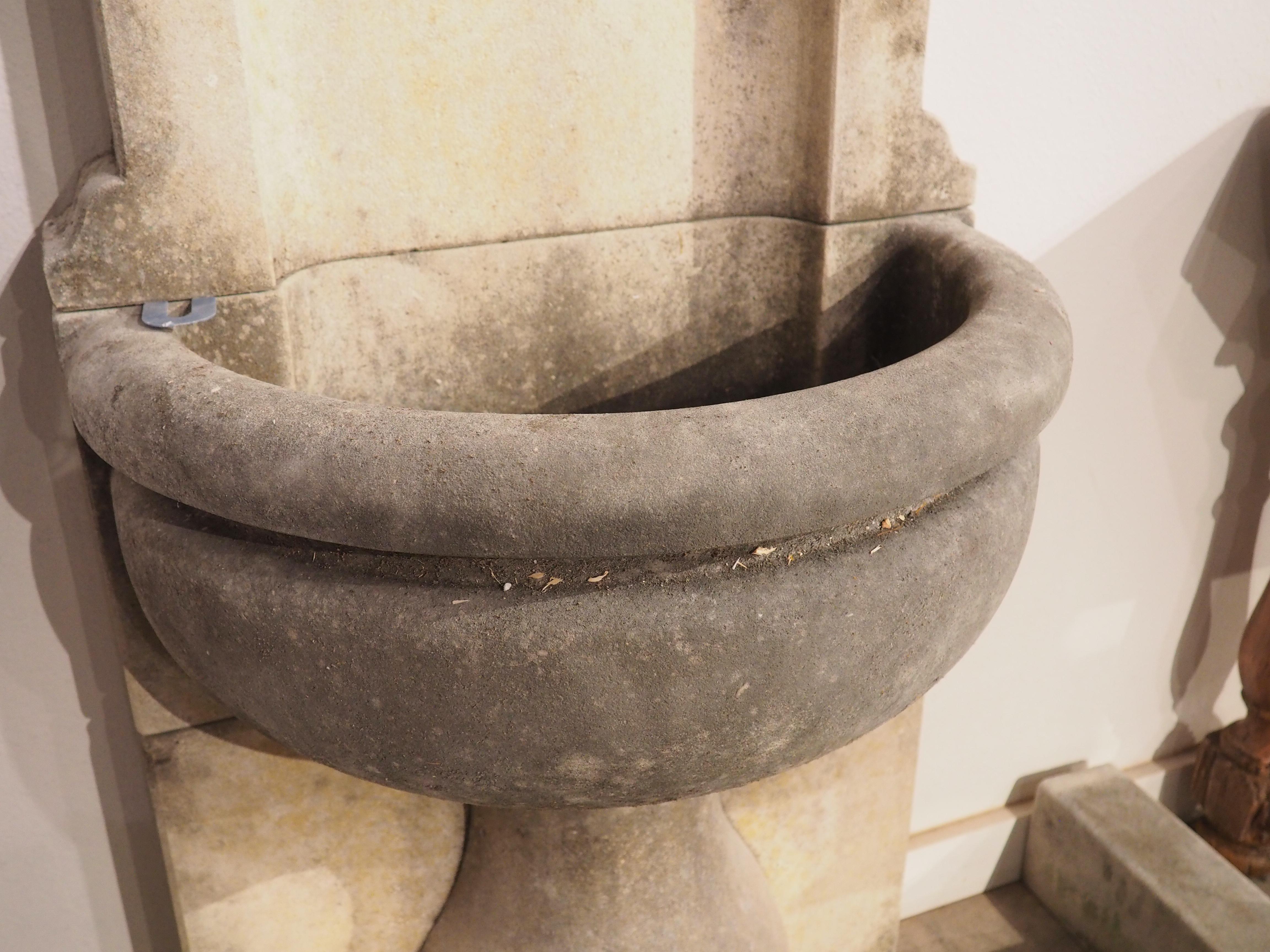 Consisting of seven pieces of Vicenza limestone, this wall fountain with surround was hand-carved in Veneto, Italy. The fountain is comprised of four blocks of stone, each with a warm, natural patina. At the foot of the fountain is a three-piece