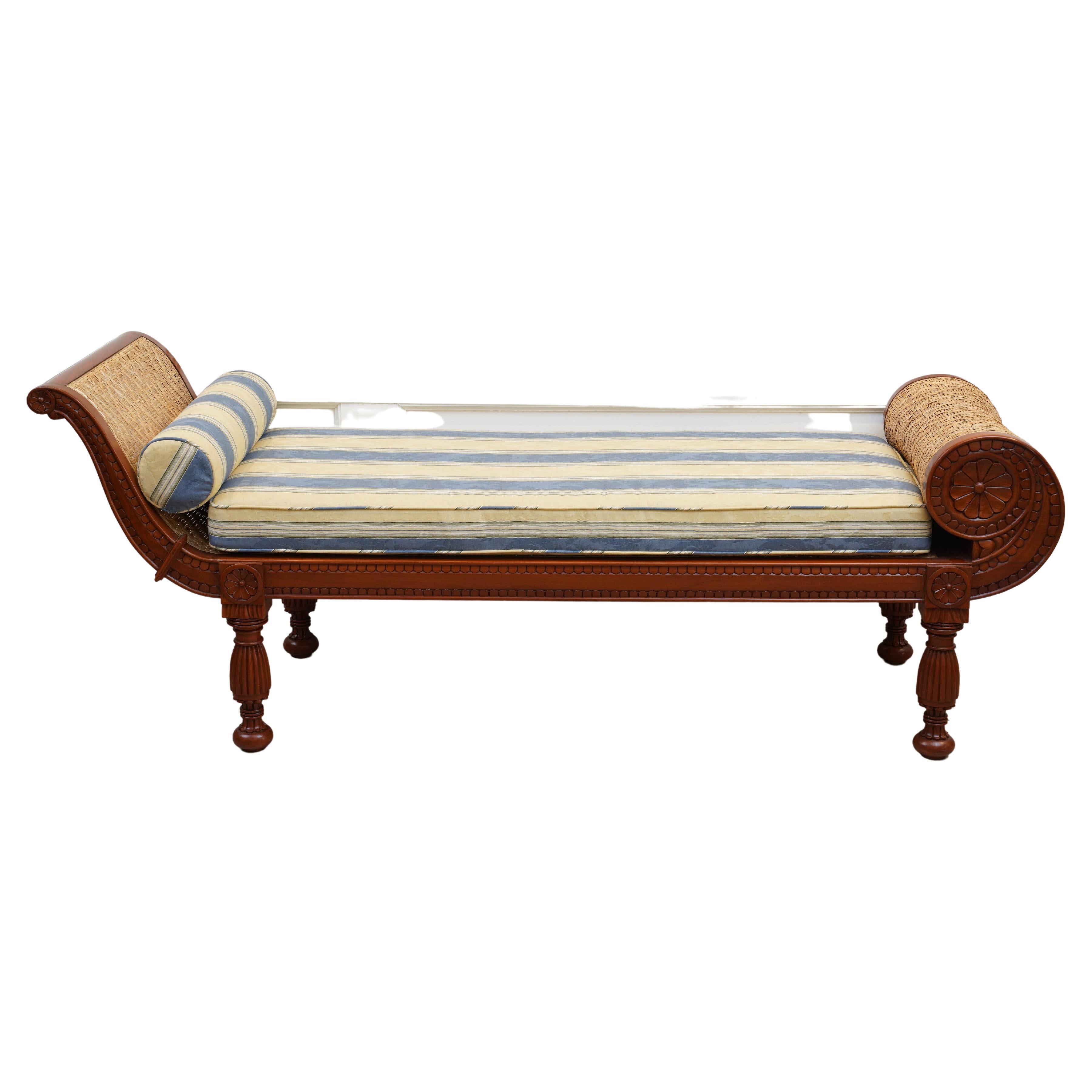 A mahogany and caned recamier or daybed with carving on both sides, a caned rolled end, and reeded legs. The caning is newly done and in a very tight woven pattern without holes, making it stronger than the usual open hole caning. The foam cushion