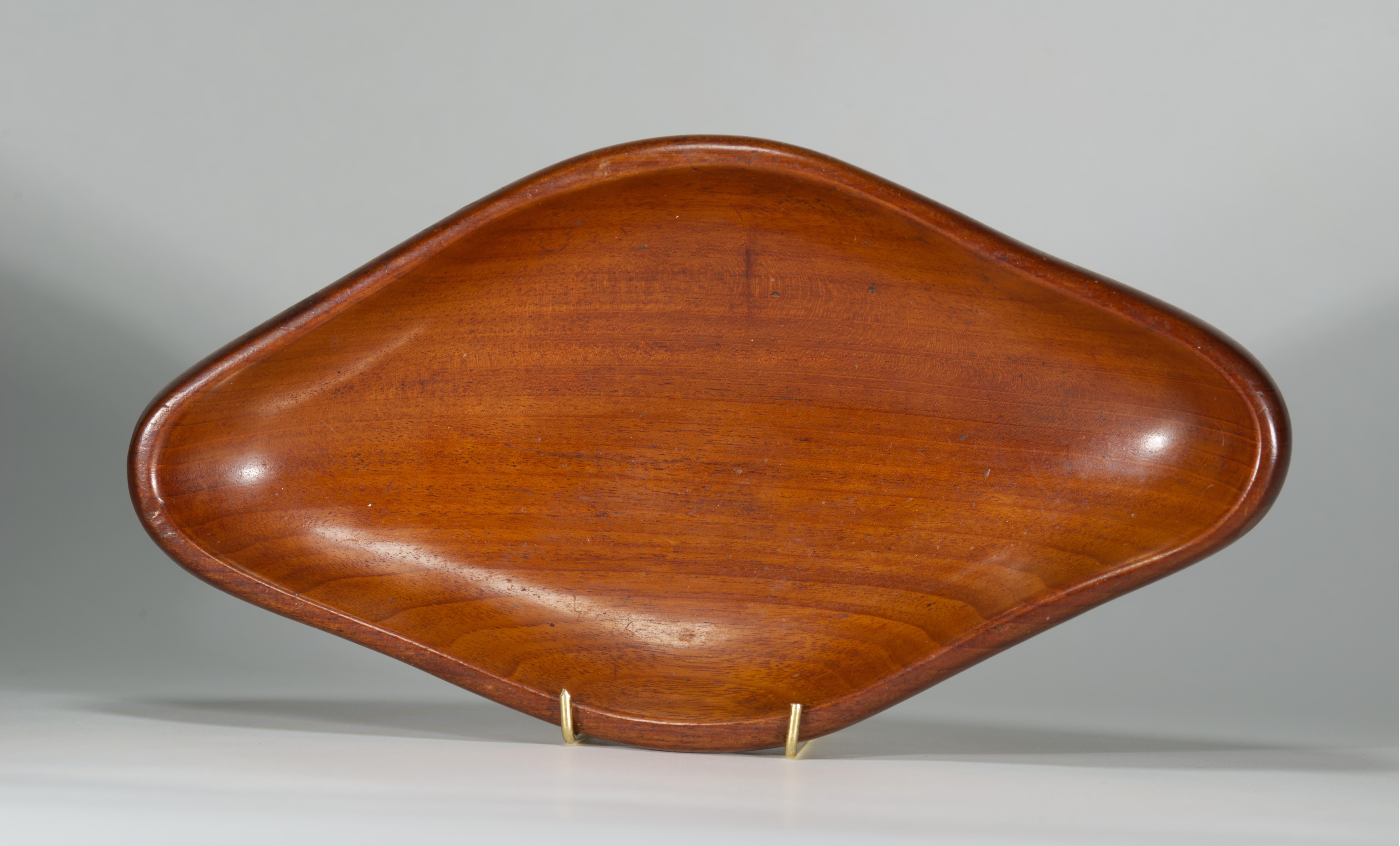 Vintage elongated carved wooden bowl features elegant Modernist style form with soft, rounded corners, that showcases the natural beauty and the rich grain of Mahogany wood. 

The bowl is done in style of hand-carved wood tray platters designed by