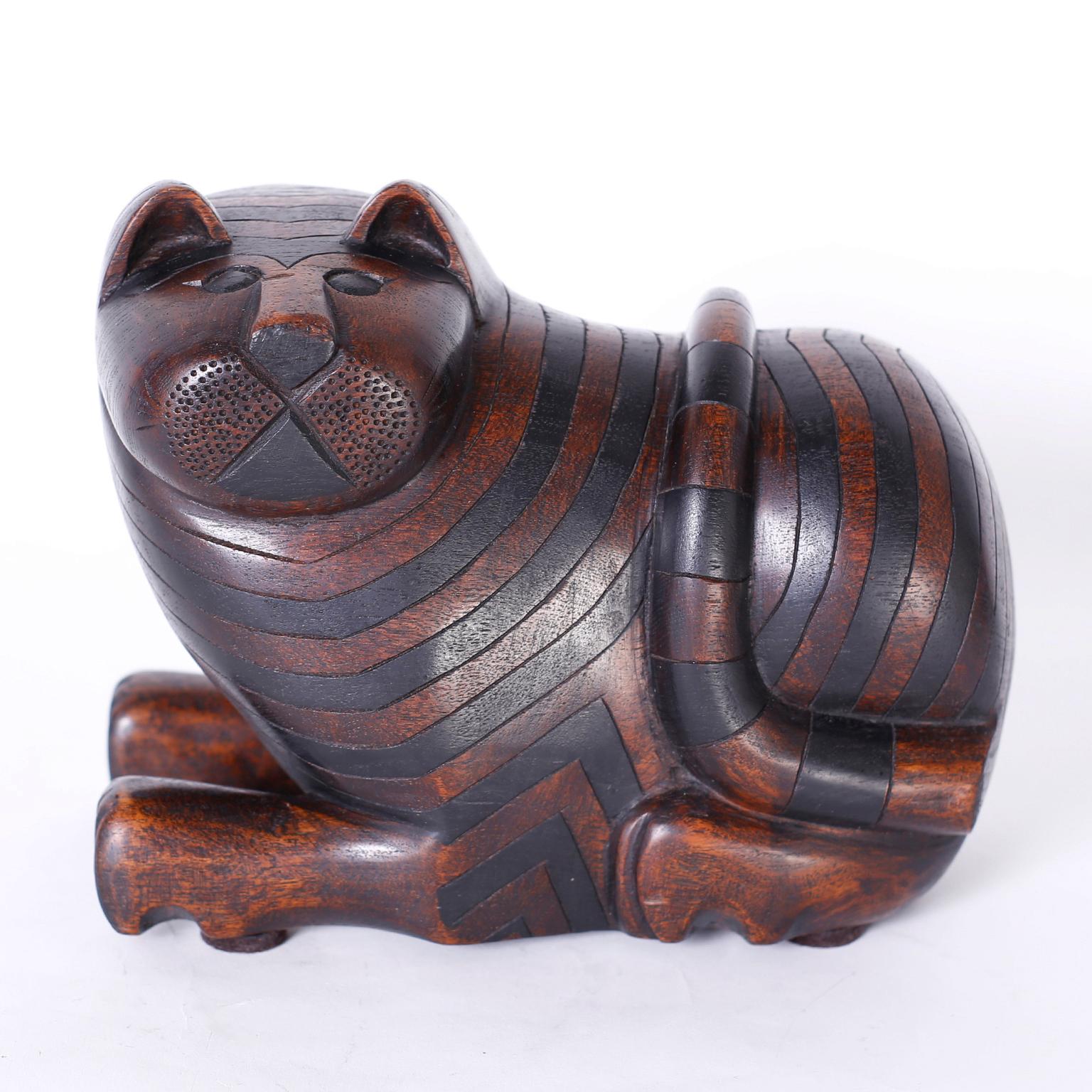 Anglo Indian carved mahogany cat with ebonized stripes and a curious expression, featuring a secret compartment on the bottom.