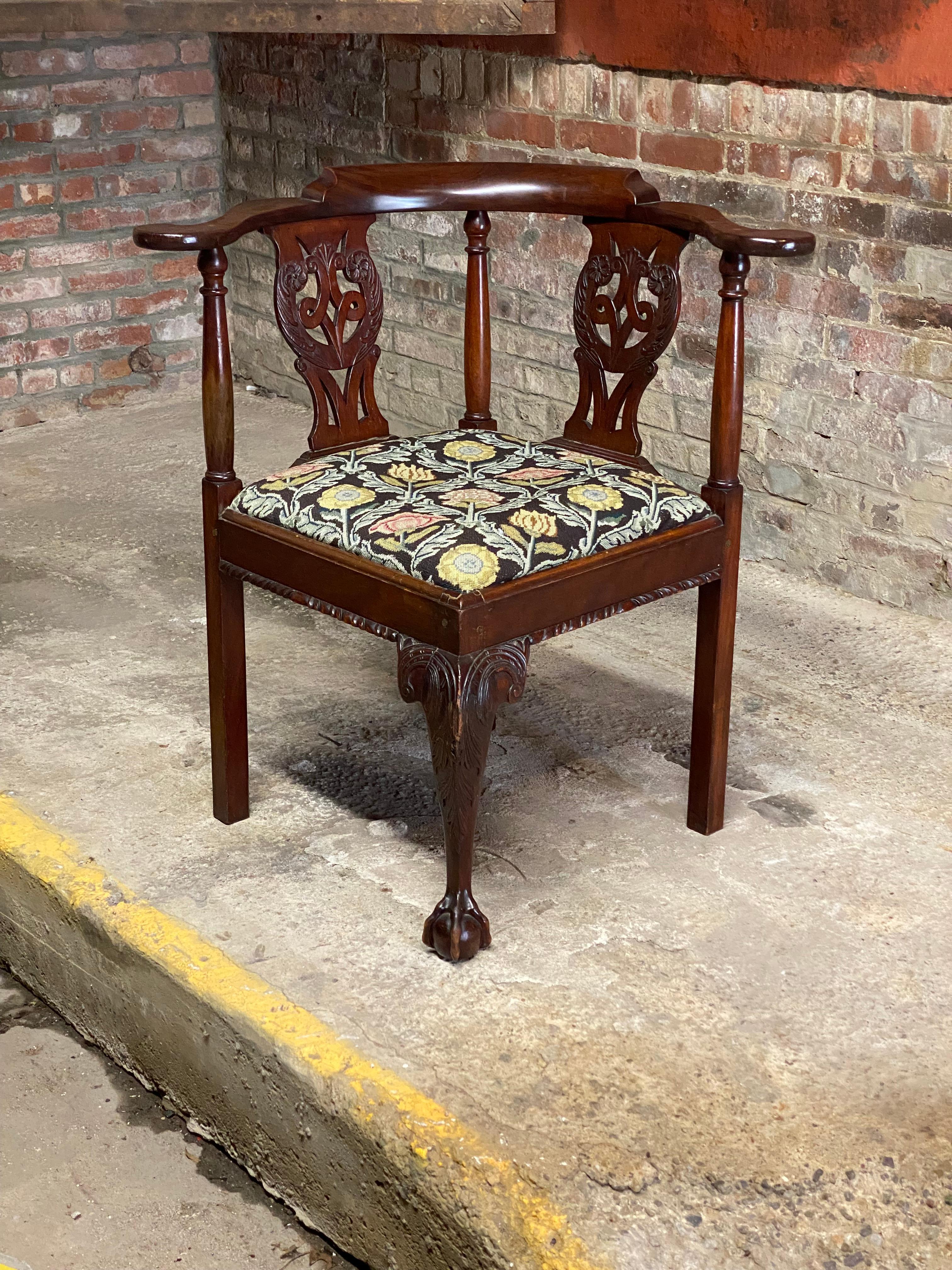 A beautiful piece of Americana. Featured is a carved Mahogany claw and ball foot corner chair with a floral needlepoint slip seat. Finely carved front middle leg with scrolling acanthus leaf design and ending in a claw and ball foot. The back and
