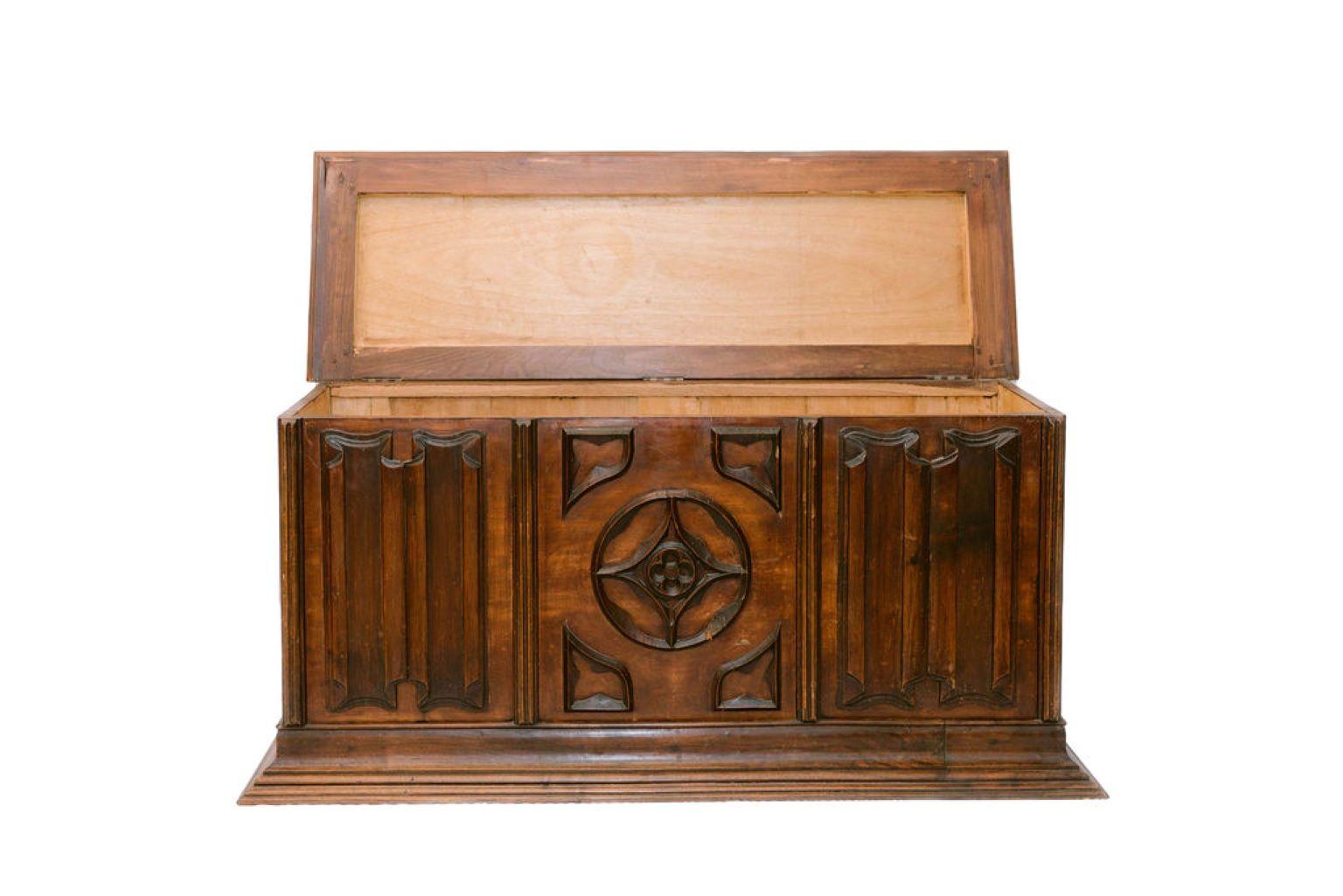 French carved Mahogany coffer, applied carved center panel with medallion, relief linenfold carved panels, fielded panel sides, and a graduated step base.