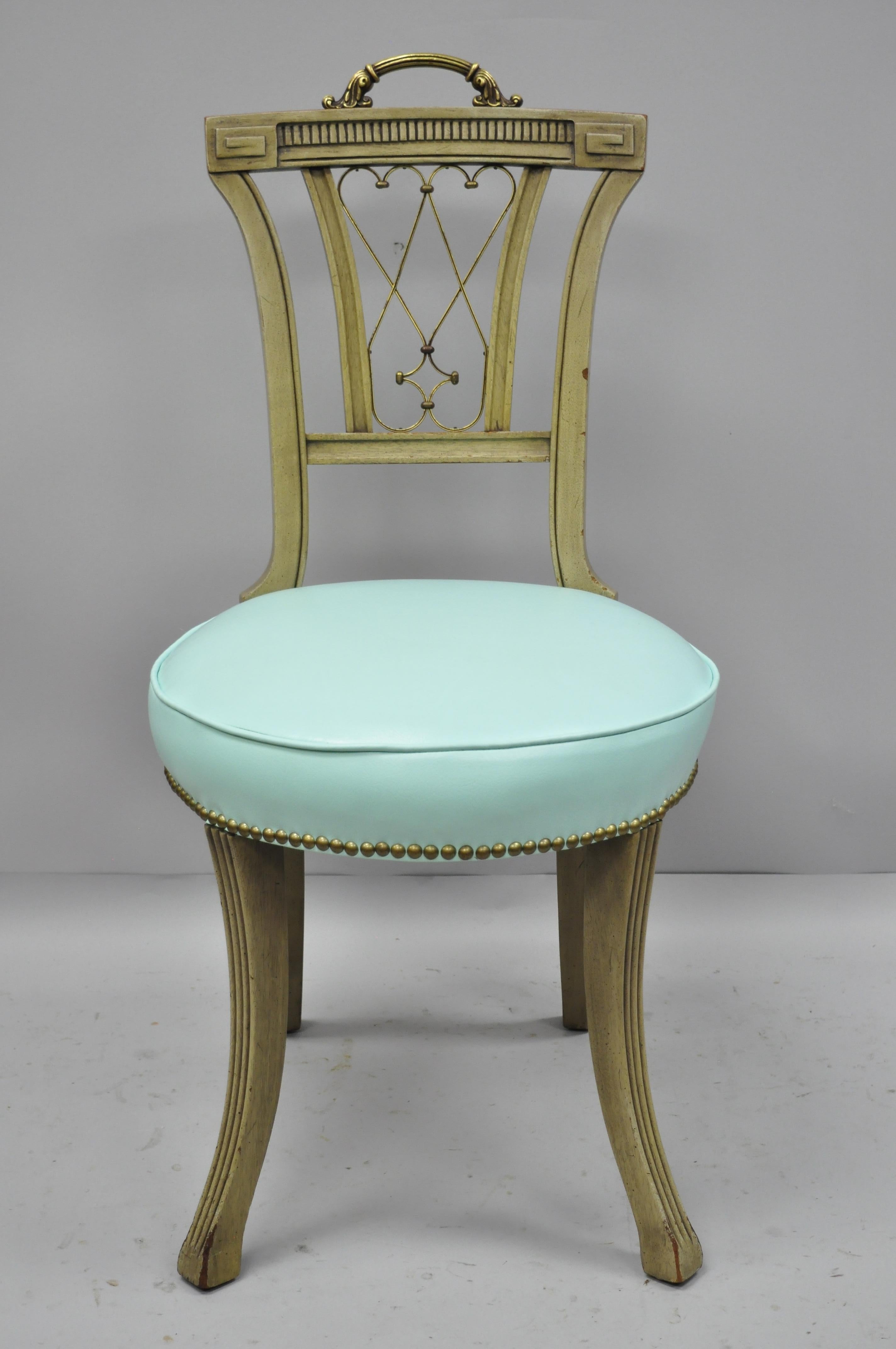 Pair of carved mahogany French Regency style chairs with brass handle and aqua vinyl. Item features ornate brass handle, brass decorated 