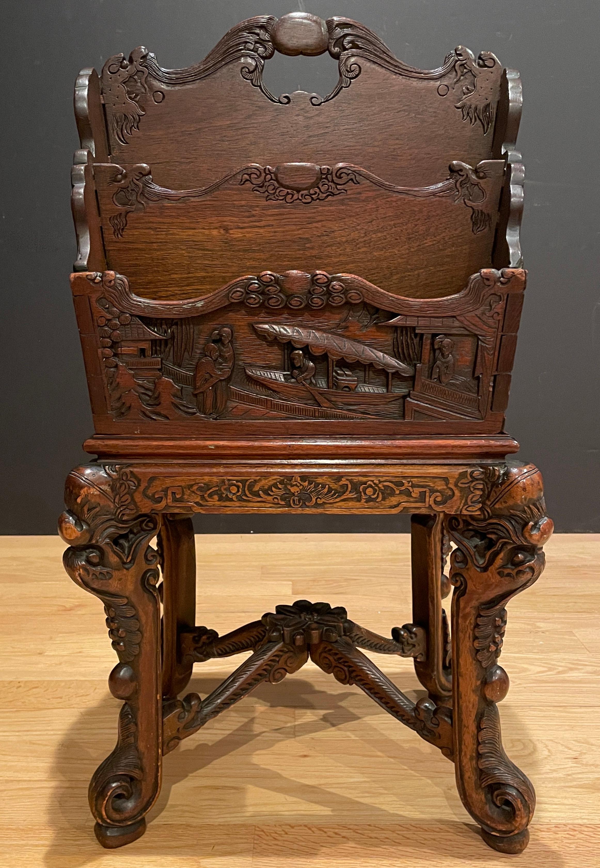 Chinoiserie hand carved teak magazine rack on stand. Figural with grape and vine pattern. 