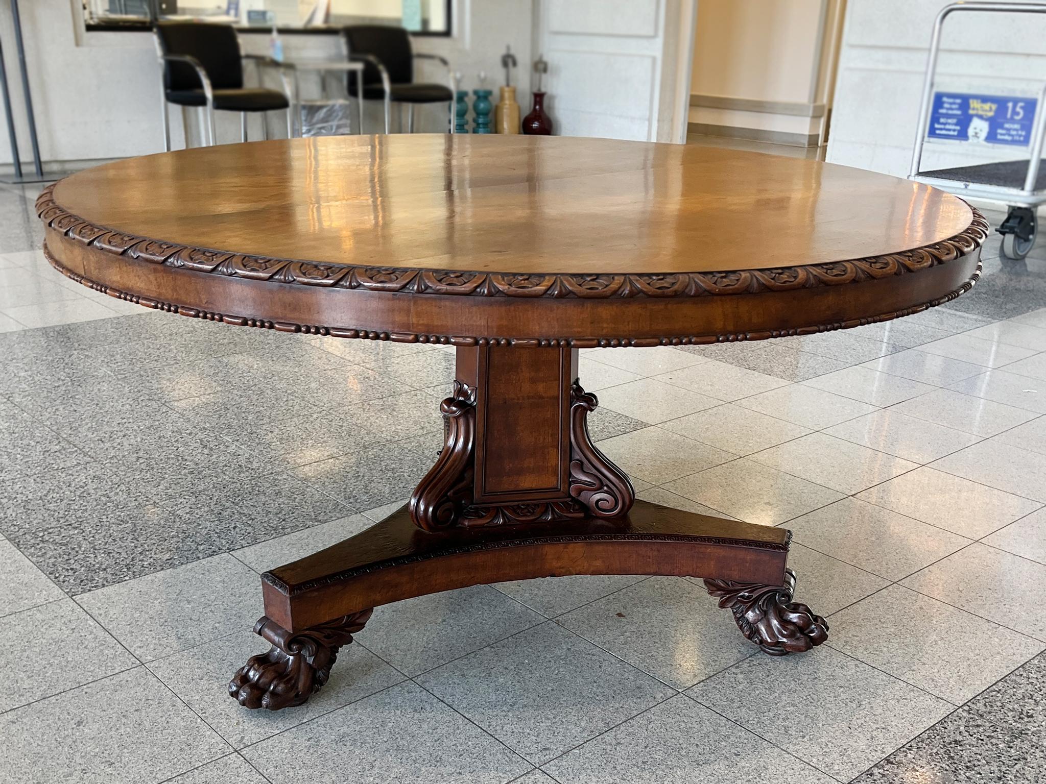 Handcrafted in the early 19th Century, this Regency era round table is newly restored. It is remarkable for its excellent craftsmanship. The details include a floral border hand-carved along the top's edges, framing the mahogany's rich natural grain