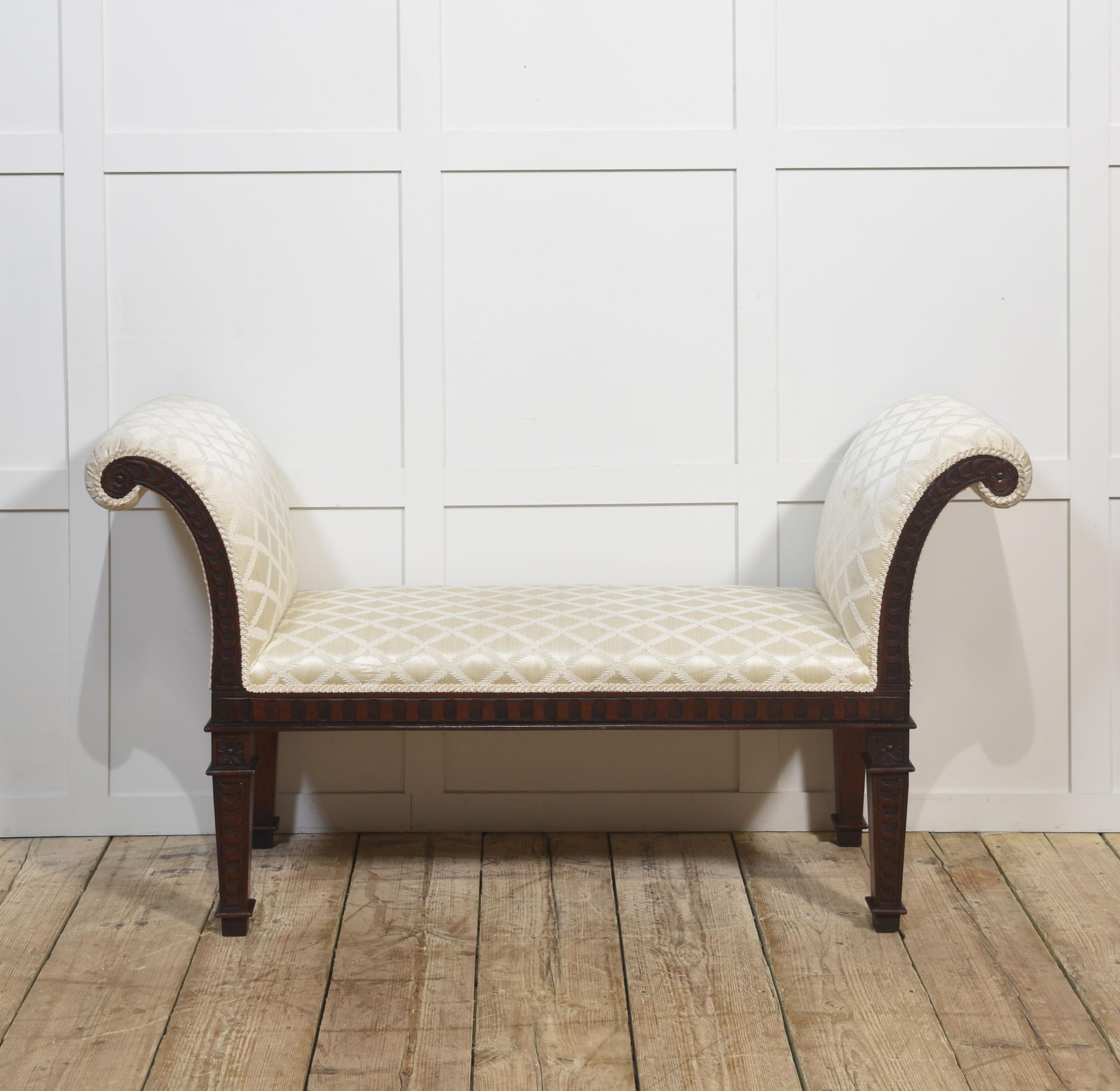This refined window seat/bench exudes timeless sophistication, blending elegant design with exceptional craftsmanship. The frame is crafted from rich mahogany, showcasing intricate hand-carved details along the legs and scrolled arms. Upholstered in