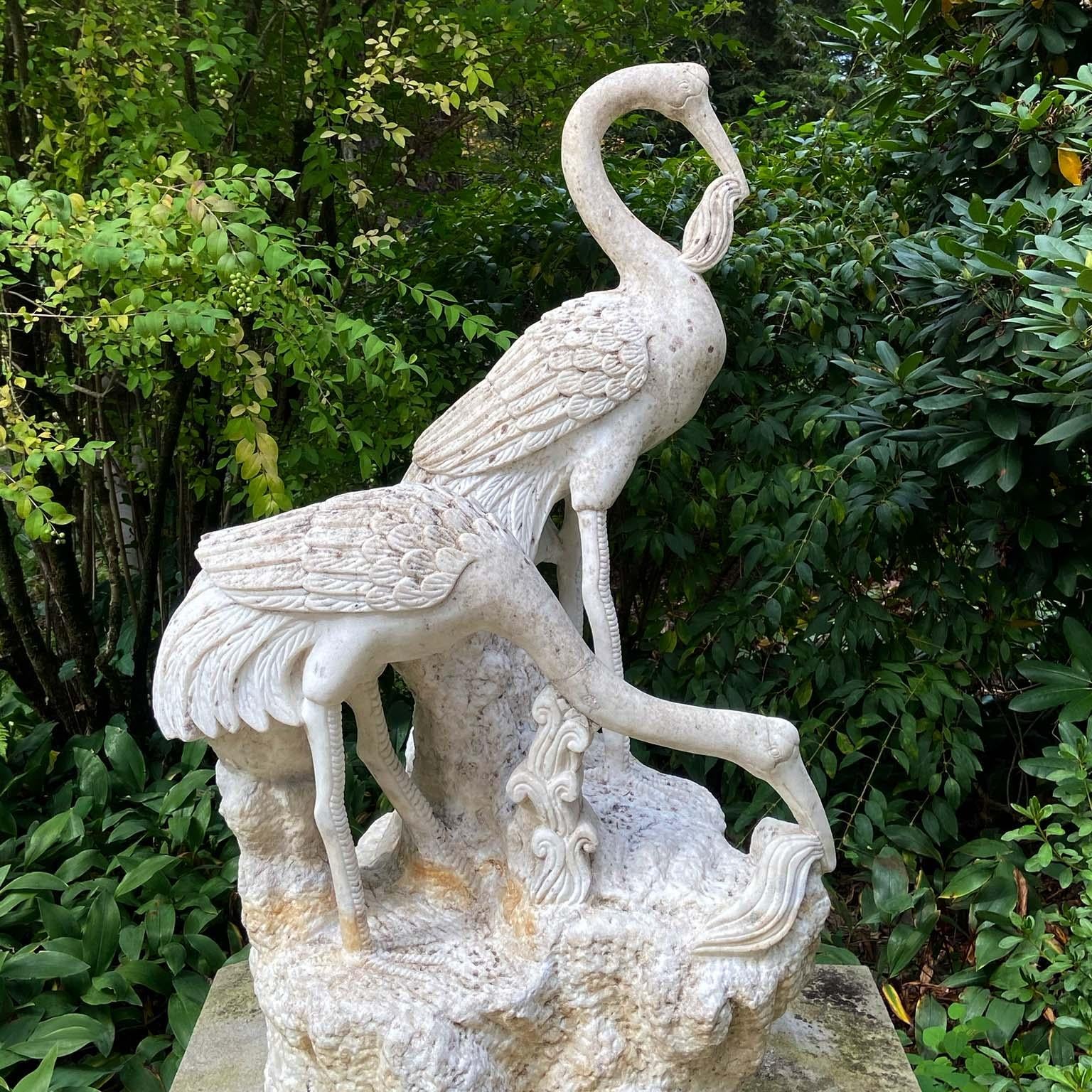 Anglais Des grues en marbre sculptées sur socle en roche