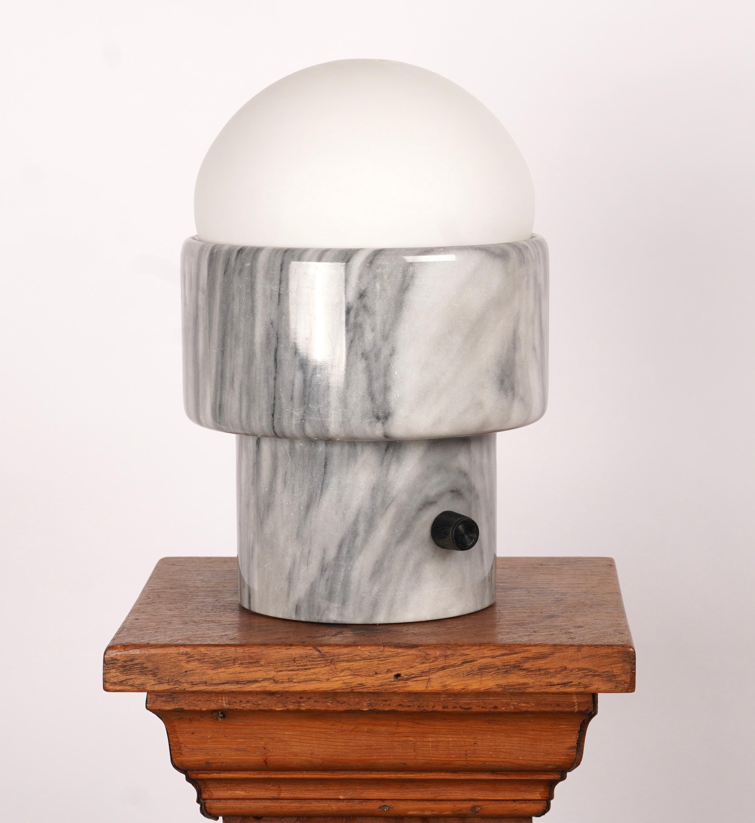 Lampe de table en marbre sculpté avec abat-jour en verre amovible. La lampe est équipée d'un gradateur de réostat intégré à l'interrupteur qui permet de régler l'intensité de la lumière. Magnifique base en marbre gris et blanc cassé.