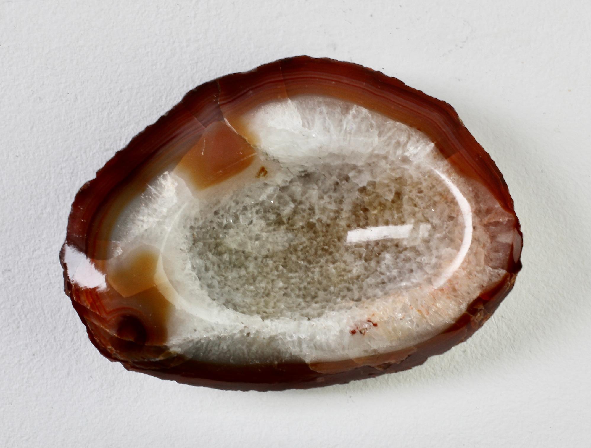 Eine schöne geschnitzte, leicht oval geformte und polierte rotbraune Steinschale, Schale, Aschenbecher oder Videopoche von einem unbekannten Hersteller. Wunderschöne organische, leicht ovale Form mit warmen Karamell-, Creme- und Brauntönen und
