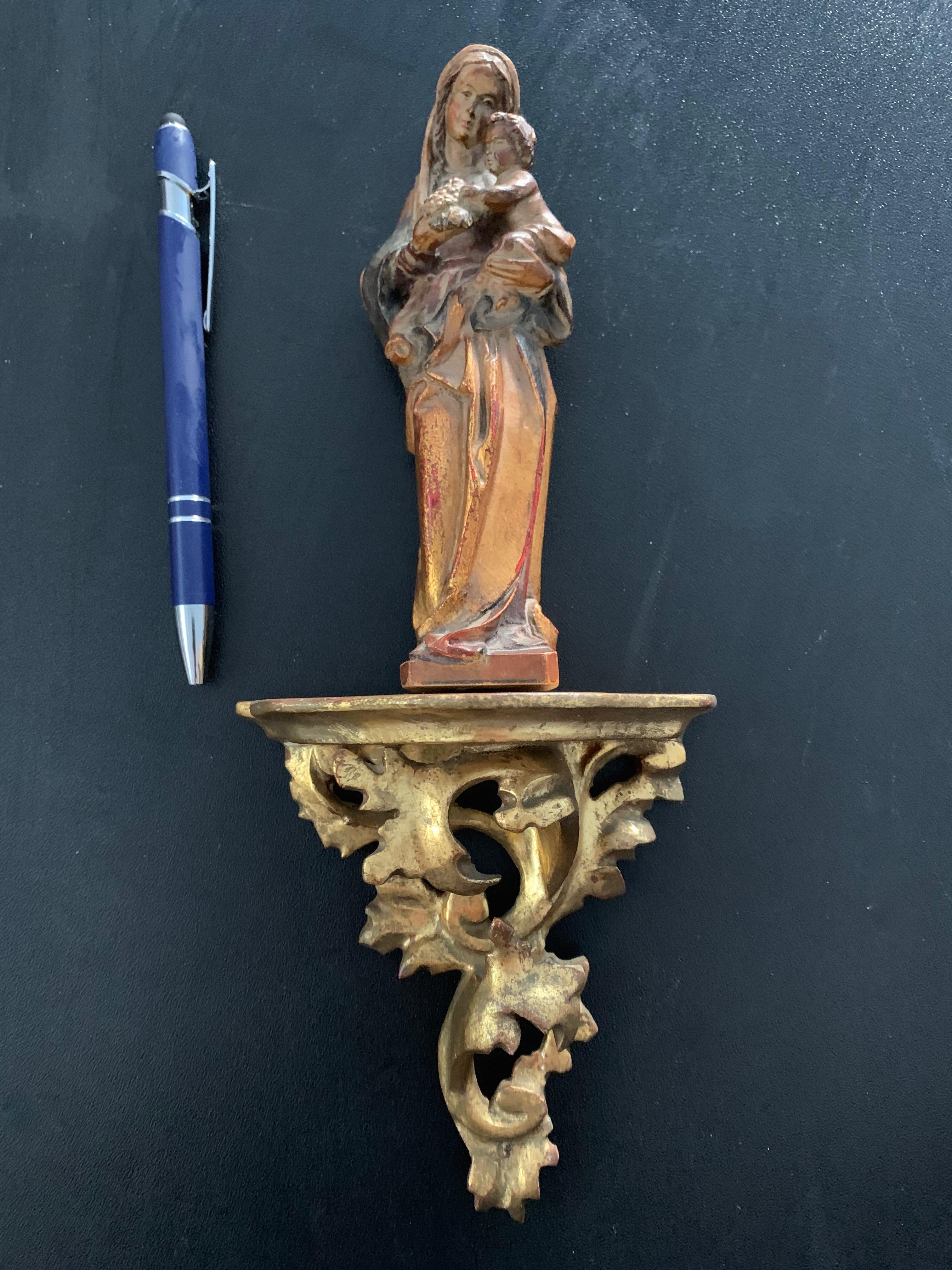 Hand painted and hand carved wooden sculpture of Holy Mary on a gilt Rococo style small bracket.

This Mother Mary and Child sculpture is gorgeous for its quality, its great colors, its warm patina and of course for what she stands for. This