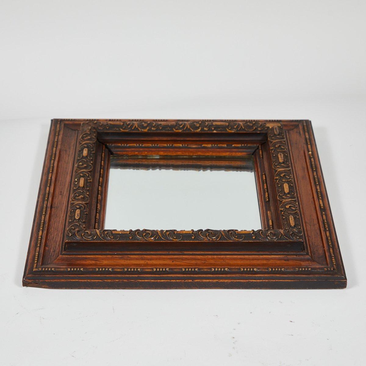 Late 19th-century English carved oak mirror with a thick square frame and beveled glass. Ornate yet understated, the piece has charming proportions and a rich natural patina. 

England, circa 1880

Dimensions: 14W x 2D x 14H