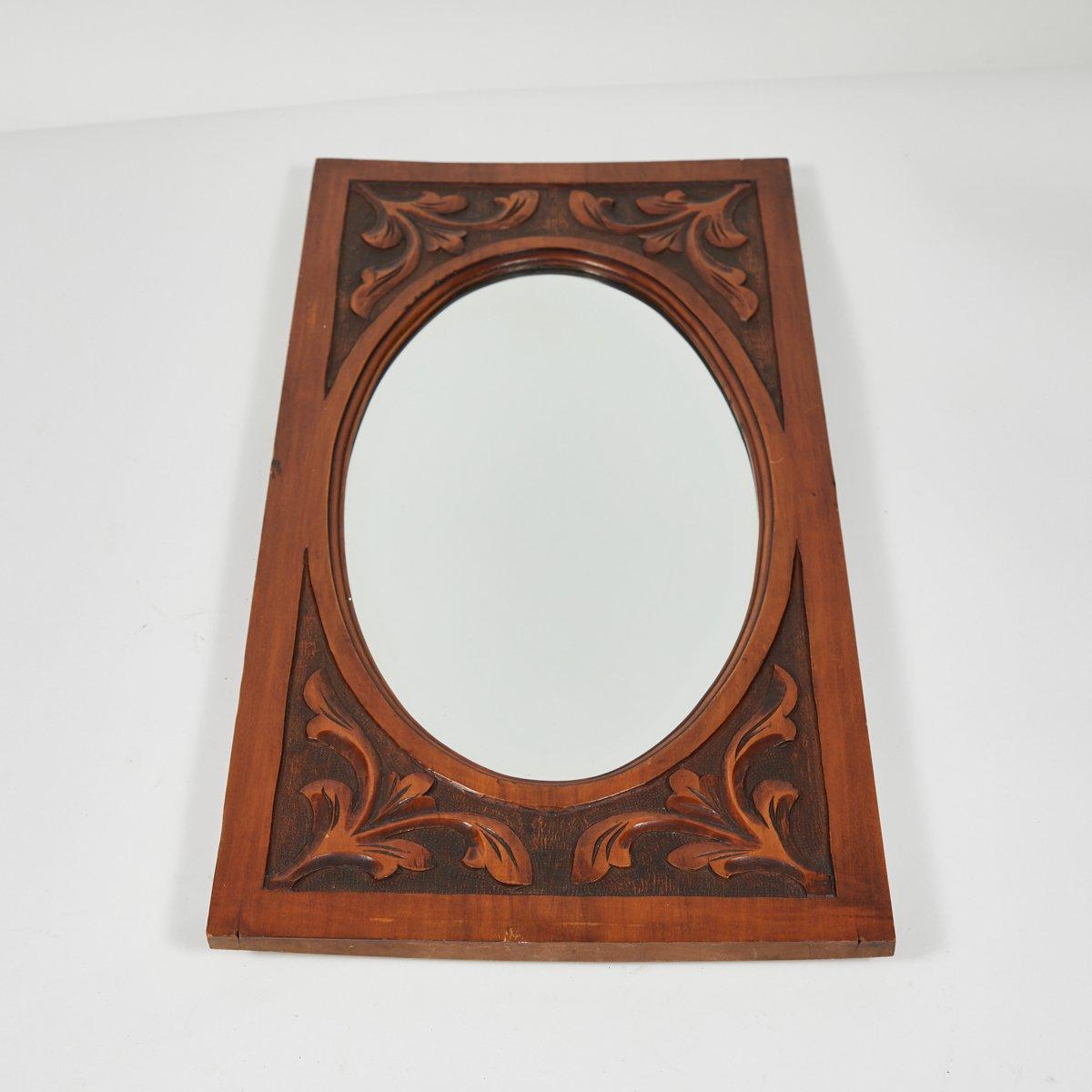 Late 19th-century English mahogany with oval beveled glass. The rectangular frame features carved bas relief floral accents and a thin, flat border. Delicate yet sturdy, the piece has an understated charm. 

England, circa 1880

Dimensions: 11W x