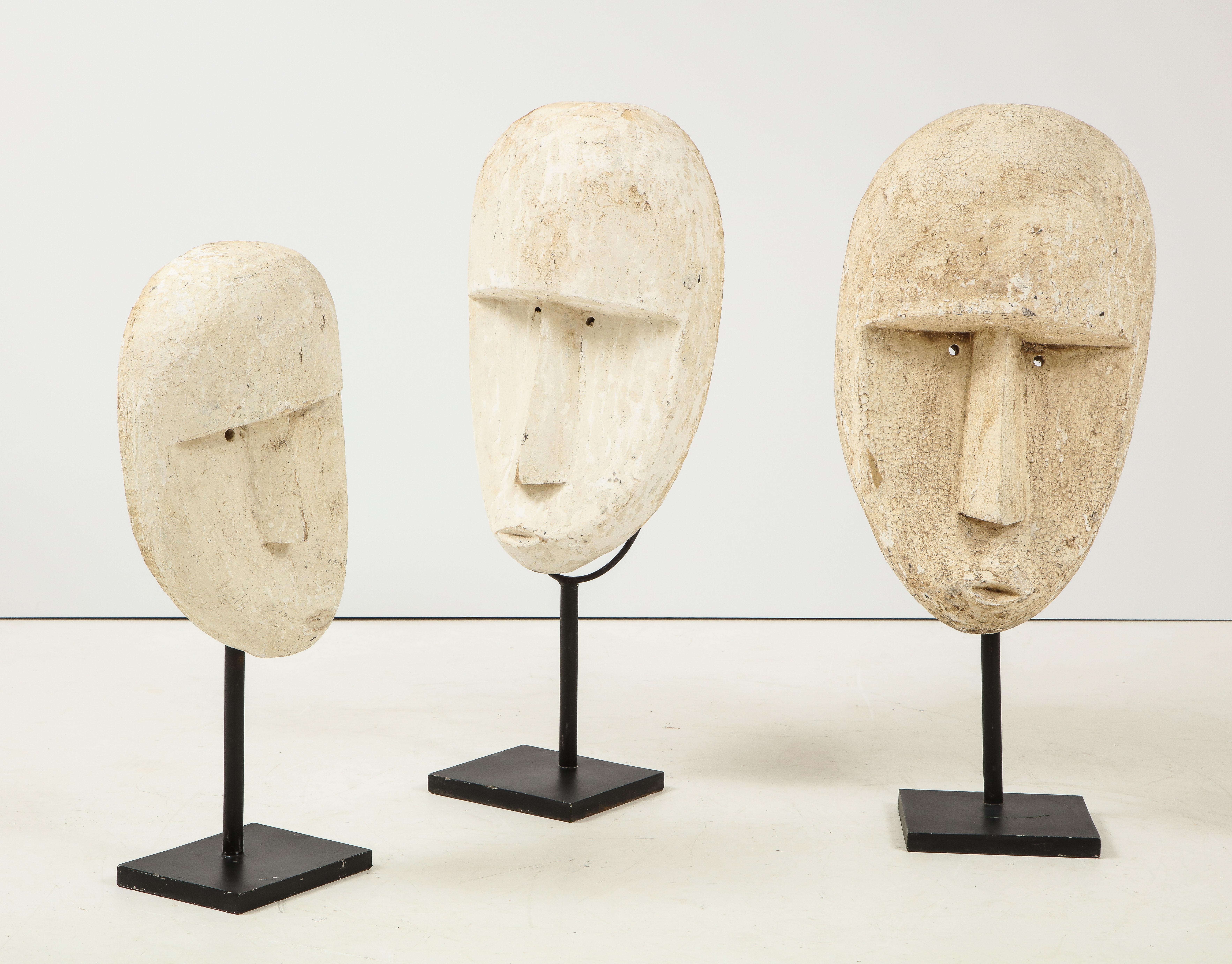 Carved modernist plaster mask sculptures mounted on painted black metal bases and supported stand.
Bali, Indonesia, circa 1970s
Size: largest (pictured on right) 37 3/4