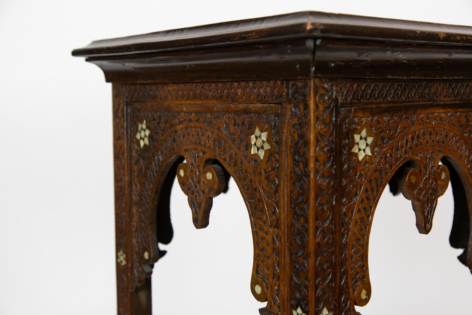 Carved Moroccan plant stand, this three-stand is heavily carved and inlaid with mother of pearl stars.