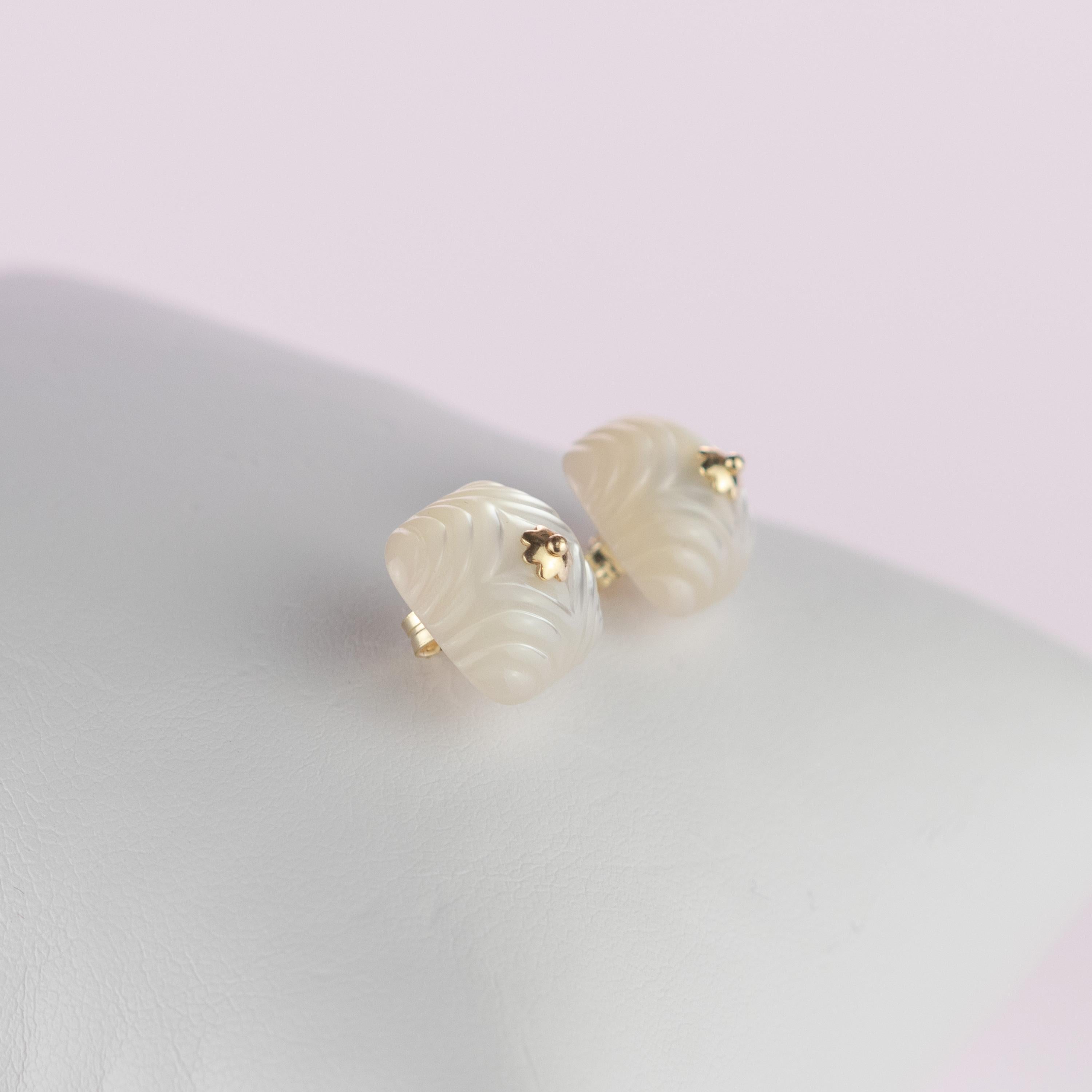 Merveilleuses boucles d'oreilles carrées en cabochon de nacre naturelle de 12,5 carats, agrémentées de détails délicats en or jaune 18 carats. Une magnifique fleur d'or à sept pétales ronds mettant en valeur le cœur du bijou, qui la traverse et