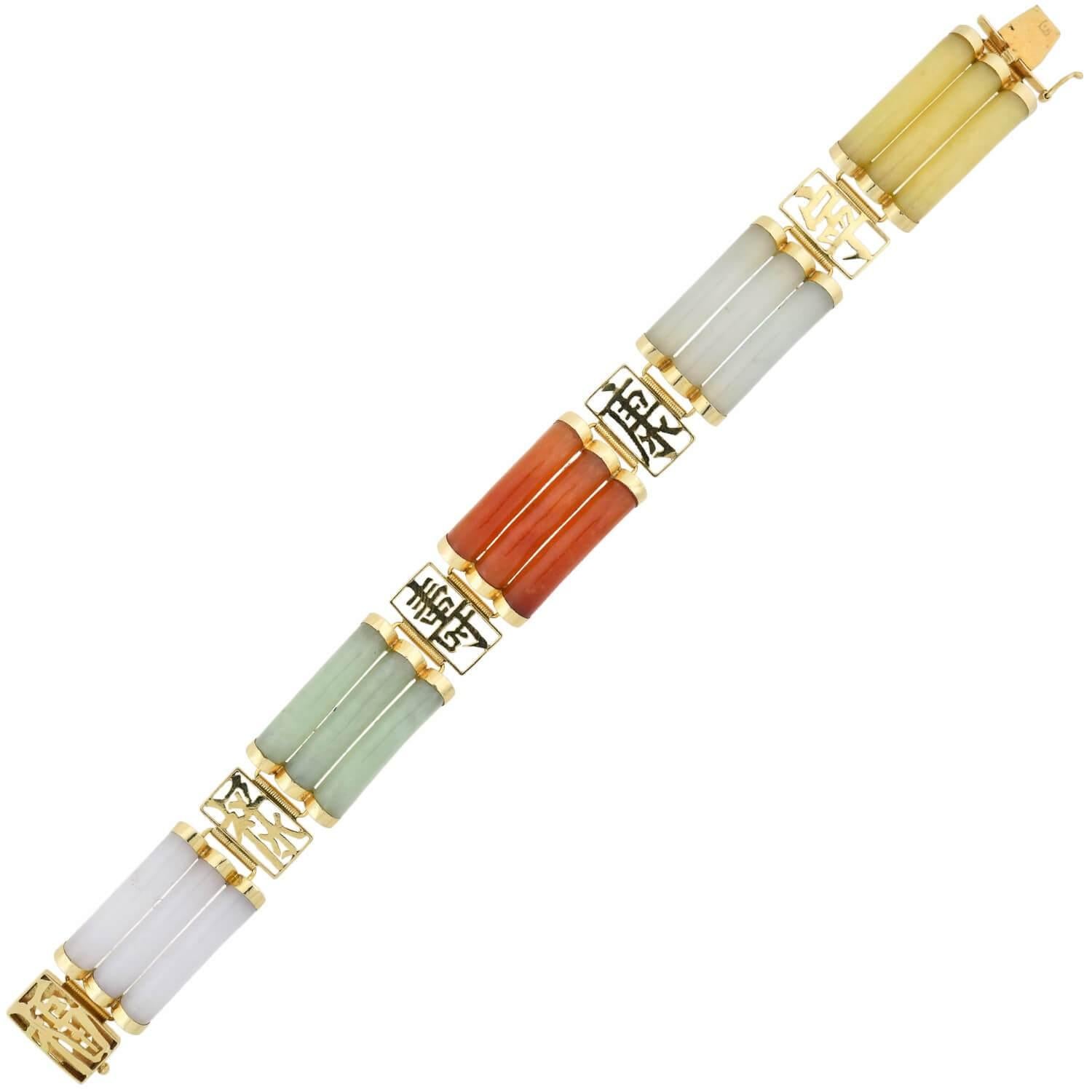 Ein lustiges und einzigartiges Jade-Armband aus der Zeit der 1960er Jahre! Das aus 14-karätigem Gelbgold gefertigte Schmuckstück zeigt ein abwechselndes Design aus mehrfarbiger Jade und offenen chinesischen Schriftzeichen. Die farbenfrohen