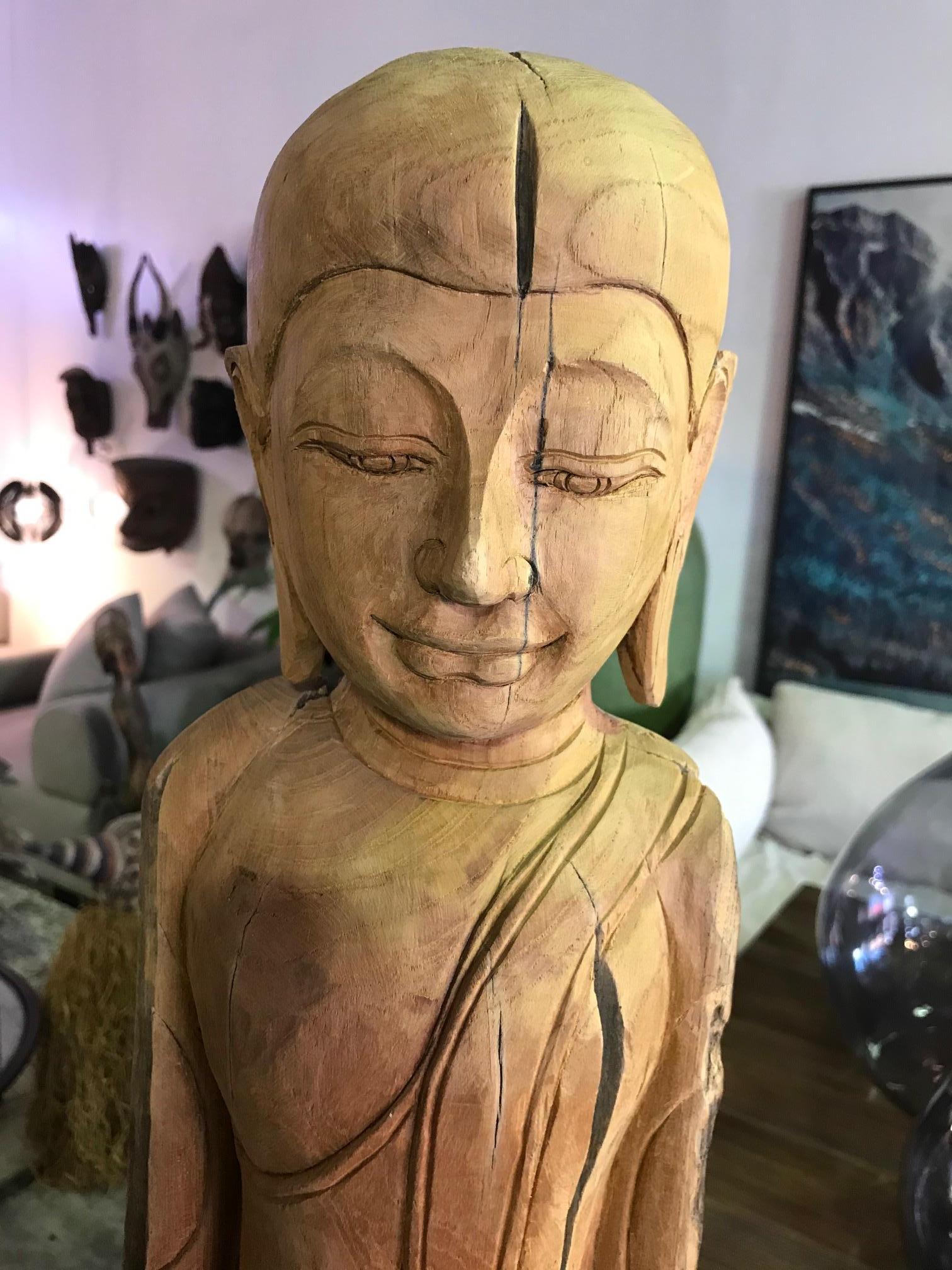 Tall hand carved wooden standing Buddha from Thailand. Beautifully carved and detailed with the wood's natural imperfections left intact. Very unusual to find like this in the figure's natural wood state and no additional adornment.

Great