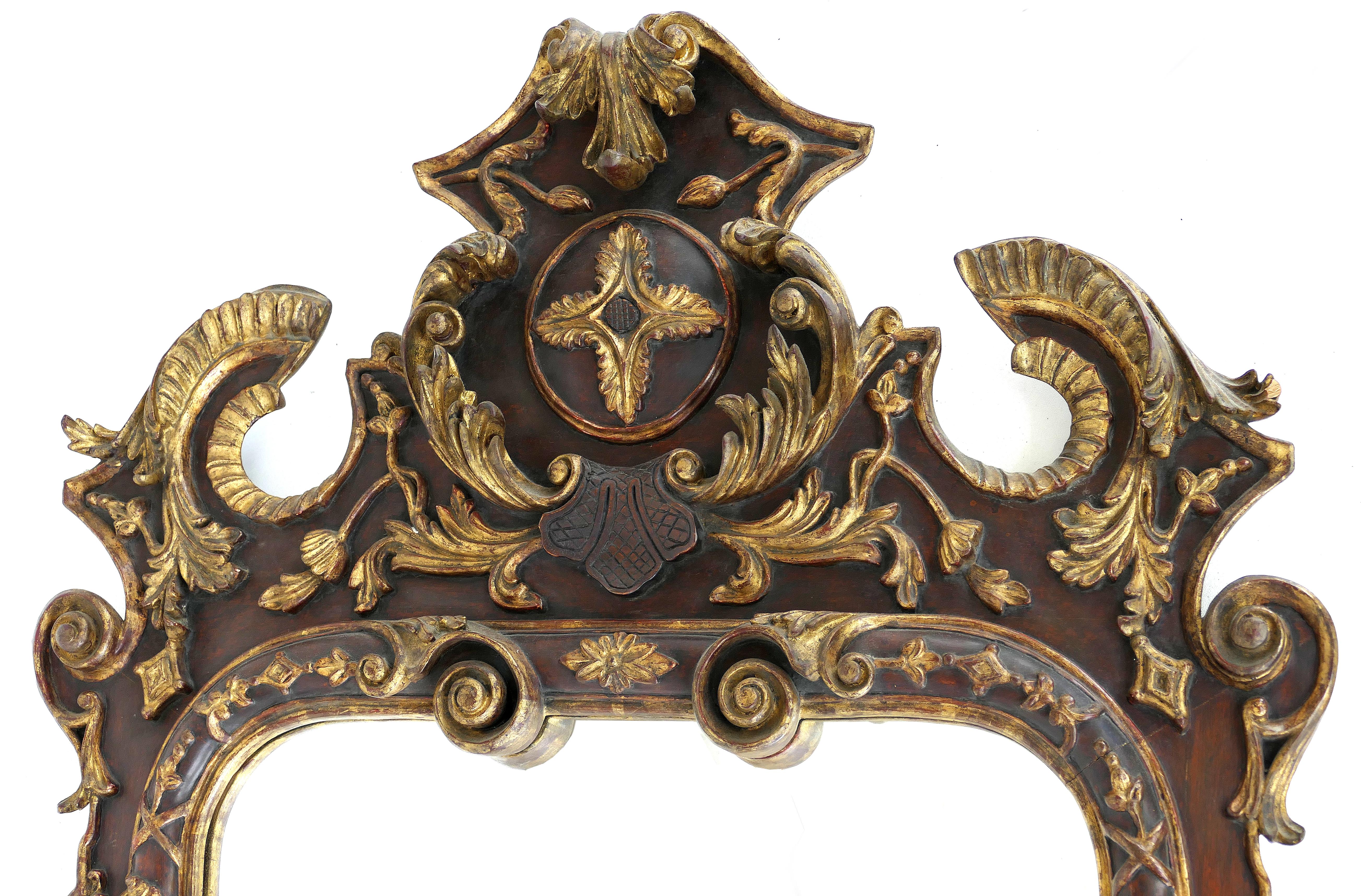 Offered for sale is an ornate heavily carved European giltwood mirror. The sides of this elegant frame have fluted columns with carved Corinthian capitals and bases. The upper and lower portions are embellished with carved and gilt acanthus leaf
