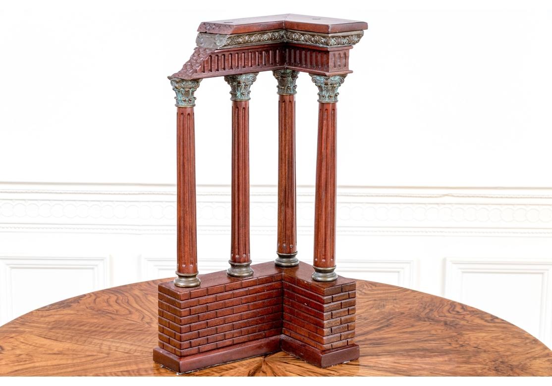 Une structure architecturale avec des colonnes cannelées néoclassiques avec des chapiteaux de style corinthien surmontées d'un mur de briques en forme de 
