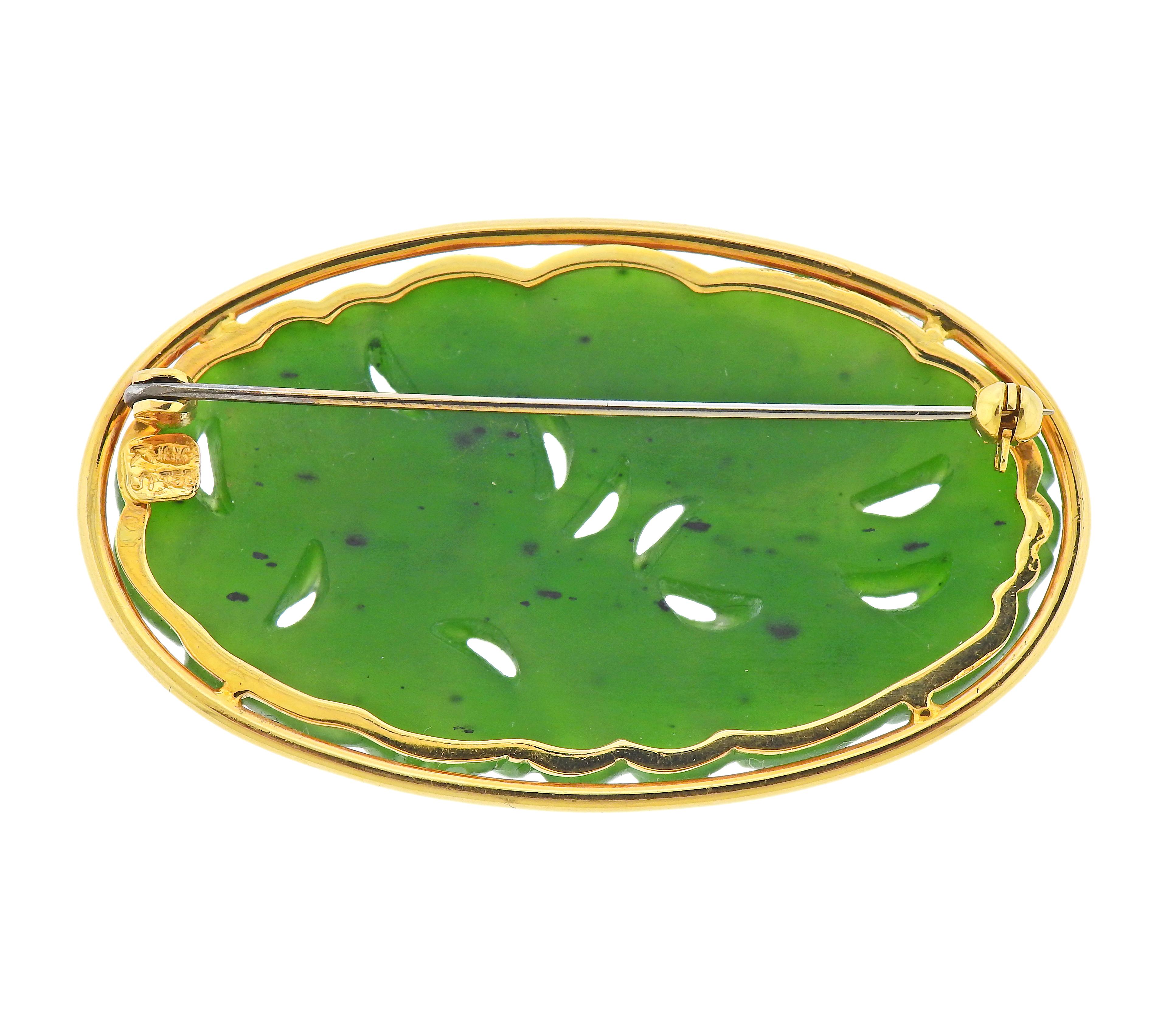 Oval 18k gold brooch with carved nephrite jade. Brooch is 53mm x 31mm. Marked 18k. Weight - 16.7 grams.