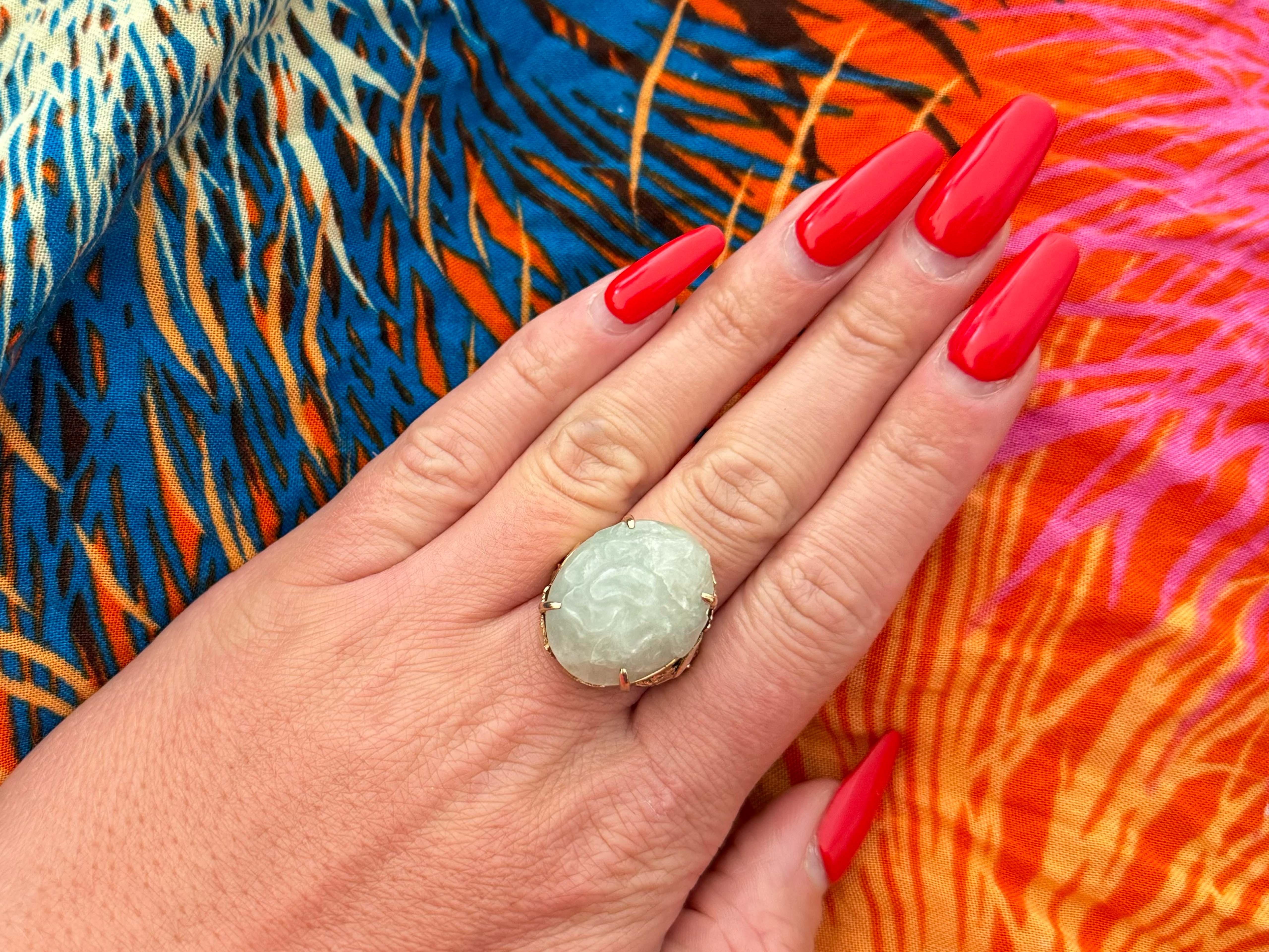 Item Specifications:

Metal: 14k Yellow Gold 

Style: Statement Ring

Ring Size: 8 (resizing available for a fee)

Total Weight: 12.7 Grams

Gemstone Specifications:
​
​Center Gemstone: Nephrite Jade

Shape: Oval

Cut: Carved

Jade Measurements:
