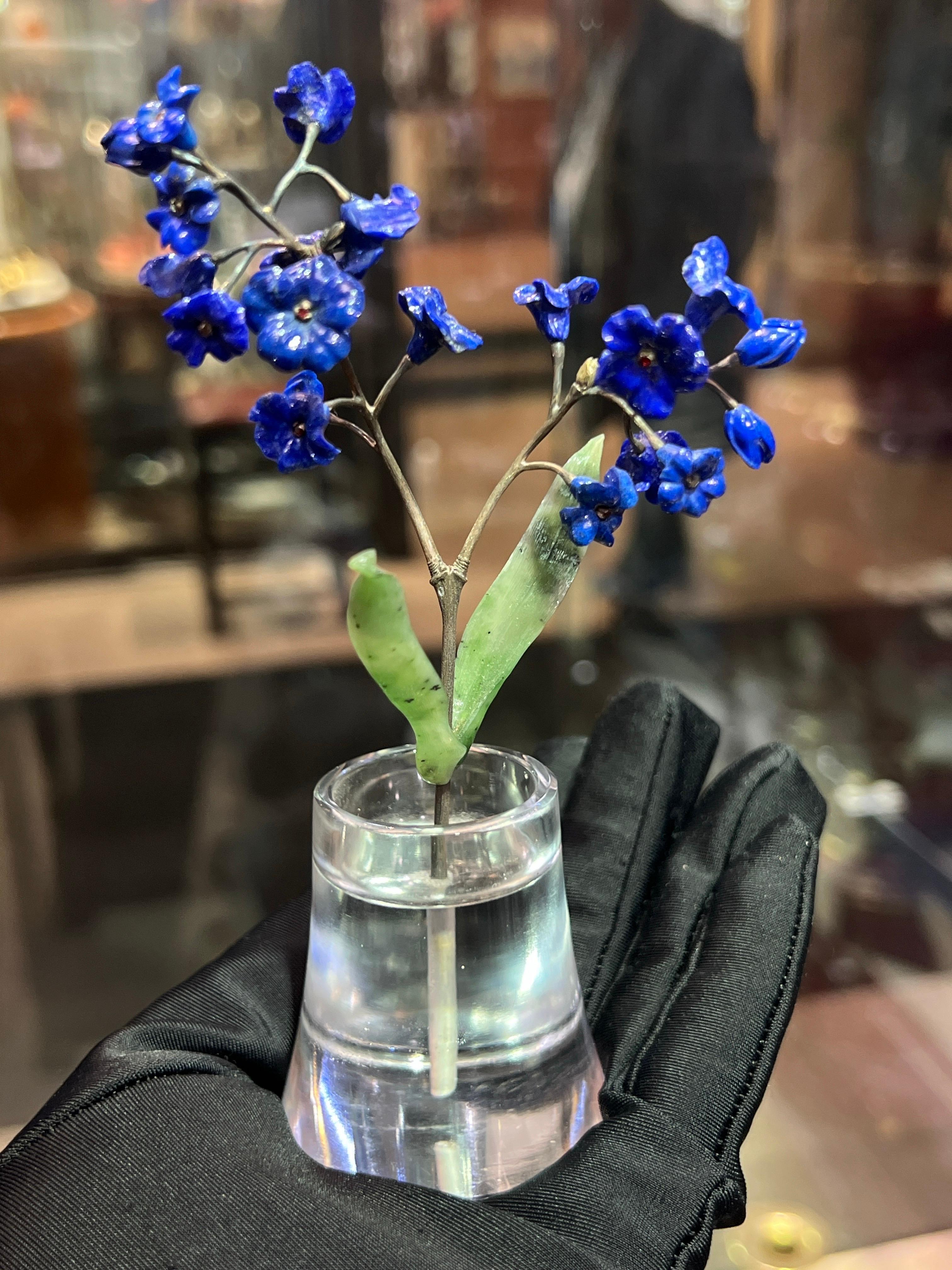 Blumentopf mit geschnitztem Nephrit, Lapislazuli und Bergkristall

Dieser Blumentopf besteht aus geschnitzten Lapislazuli-Blüten mit Rubinen im Rundschliff in der Mitte, Nephritblättern und Silberstielen. Der Sockel ist aus klarem Bergkristall